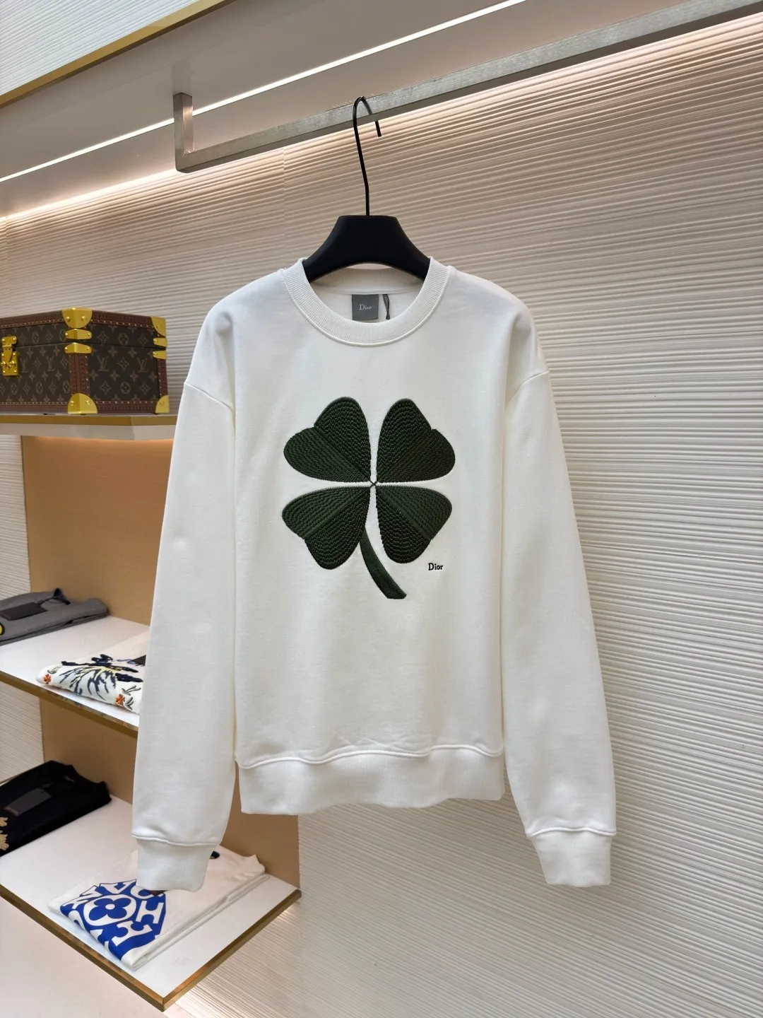 Dior four-leaf clover round neck sweatshirt ●Original version: purchased and developed by 19189 ●Item number: 1682447-A55 ●Material: pure cotton terry bottom sweatshirt fabric ●Technology: hollow embroidery production of coarse wool yarn ●Color: white ●Version: fitted version ●Weight: about 565 grams ●Size: XS-S-M-L ●Description: It adopts a fleece fabric structure of 26-count double yarn surface + 10-count yarn bottom, with a weight of 380g/㎡; with the same weight of 21-count 1x1 rib 470g/㎡. The 26-count double yarn forms a smooth and dense outer surface, and the 10-count yarn base is precisely brushed to form a rich and uniform velvet layer, thereby simultaneously achieving a crisp and skeletal feel on the outside and a skin-friendly touch like cloud velvet on the inside. Ribbing is used on the collar, cuffs and hem. Its extremely high weight and density ensure the ultimate thickness, resilience and deformation resistance of these closing parts, and together with the body, create a full and three-dimensional silhouette. The white color highlights the pure and delicate texture of the fabric and the pile loop texture on the bottom. The Dior Clover embroidery on the front uses hollow embroidery technology of coarse wool yarn. Refers to the use of special embroidery thread that is thicker and may have a plush texture. Its function is to give the embroidery pattern a unique fluffy, three-dimensional and soft touch, imitating the effect of wool weaving or tufting. This is an embroidery technique that uses specific stitches to make embroidery threads form an annular or hoop-like structure on the surface of the fabric. The embroidery thread does not adhere closely to the fabric, but forms tiny air circles, creating an extremely full, three-dimensional and elastic embroidery surface. The combination of the two creates a four-leaf clover pattern that is visually eye-catching, tactilely fluffy, and extremely handmade and artistic, forming a sharp and interesting contrast with the smooth white suede. The overall wiring is straight and delicate, the fabric is comfortable and soft, and the color is consistent without color difference. It can be matched with the same style to create a fashionable look and control various occasions. Customized accessories, complete with three standards, same style for men and women!