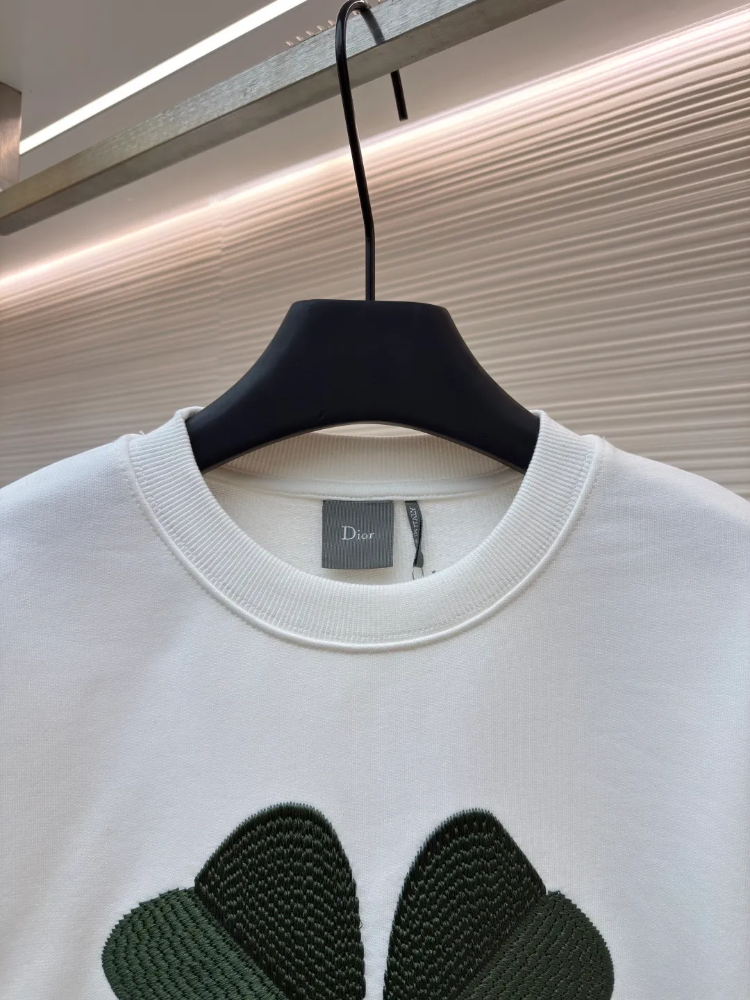 Dior four-leaf clover round neck sweatshirt ●Original version: purchased and developed by 19189 ●Item number: 1682447-A55 ●Material: pure cotton terry bottom sweatshirt fabric ●Technology: hollow embroidery production of coarse wool yarn ●Color: white ●Version: fitted version ●Weight: about 565 grams ●Size: XS-S-M-L ●Description: It adopts a fleece fabric structure of 26-count double yarn surface + 10-count yarn bottom, with a weight of 380g/㎡; with the same weight of 21-count 1x1 rib 470g/㎡. The 26-count double yarn forms a smooth and dense outer surface, and the 10-count yarn base is precisely brushed to form a rich and uniform velvet layer, thereby simultaneously achieving a crisp and skeletal feel on the outside and a skin-friendly touch like cloud velvet on the inside. Ribbing is used on the collar, cuffs and hem. Its extremely high weight and density ensure the ultimate thickness, resilience and deformation resistance of these closing parts, and together with the body, create a full and three-dimensional silhouette. The white color highlights the pure and delicate texture of the fabric and the pile loop texture on the bottom. The Dior Clover embroidery on the front uses hollow embroidery technology of coarse wool yarn. Refers to the use of special embroidery thread that is thicker and may have a plush texture. Its function is to give the embroidery pattern a unique fluffy, three-dimensional and soft touch, imitating the effect of wool weaving or tufting. This is an embroidery technique that uses specific stitches to make embroidery threads form an annular or hoop-like structure on the surface of the fabric. The embroidery thread does not adhere closely to the fabric, but forms tiny air circles, creating an extremely full, three-dimensional and elastic embroidery surface. The combination of the two creates a four-leaf clover pattern that is visually eye-catching, tactilely fluffy, and extremely handmade and artistic, forming a sharp and interesting contrast with the smooth white suede. The overall wiring is straight and delicate, the fabric is comfortable and soft, and the color is consistent without color difference. It can be matched with the same style to create a fashionable look and control various occasions. Customized accessories, complete with three standards, same style for men and women!