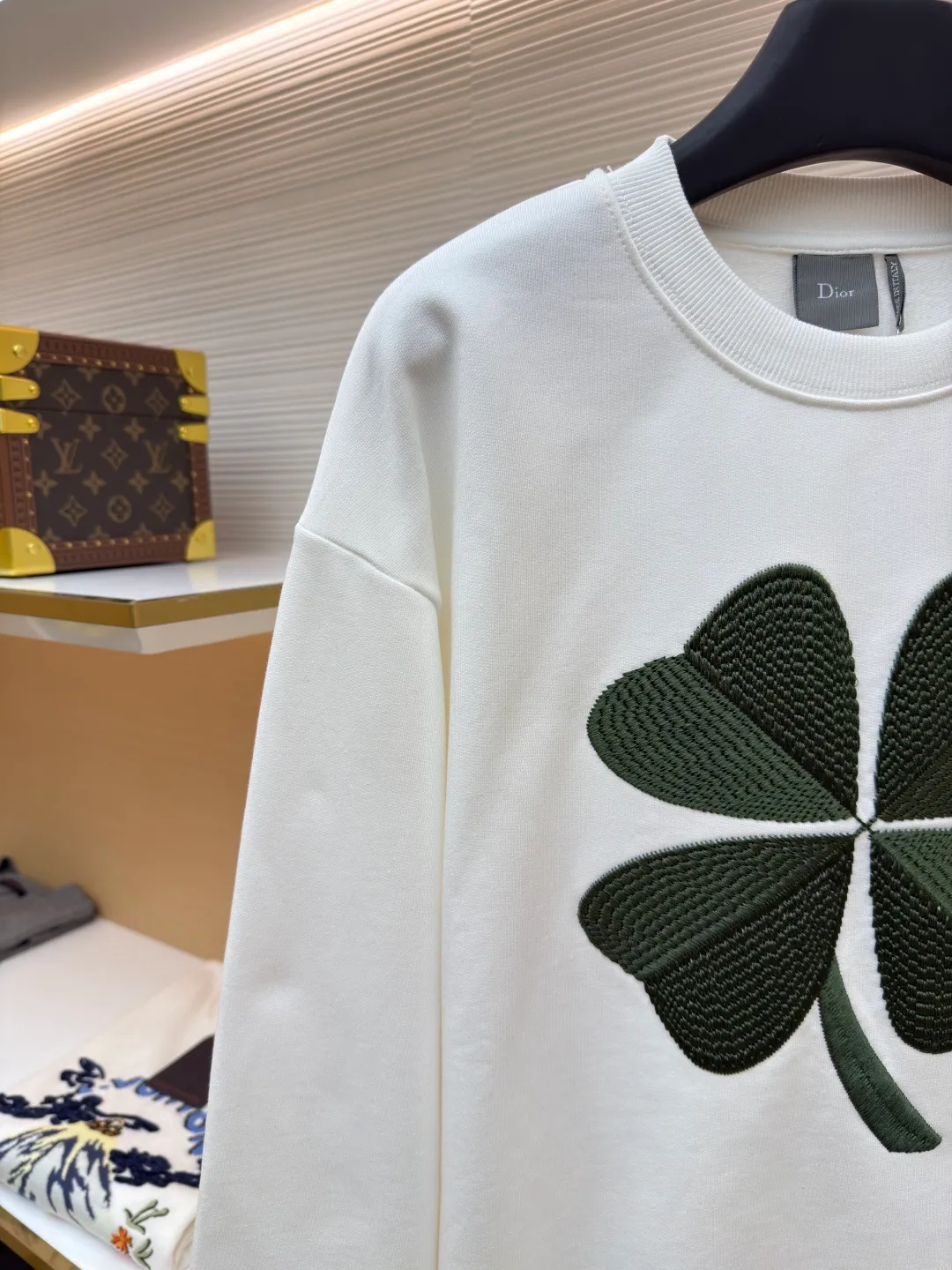 Dior four-leaf clover round neck sweatshirt ●Original version: purchased and developed by 19189 ●Item number: 1682447-A55 ●Material: pure cotton terry bottom sweatshirt fabric ●Technology: hollow embroidery production of coarse wool yarn ●Color: white ●Version: fitted version ●Weight: about 565 grams ●Size: XS-S-M-L ●Description: It adopts a fleece fabric structure of 26-count double yarn surface + 10-count yarn bottom, with a weight of 380g/㎡; with the same weight of 21-count 1x1 rib 470g/㎡. The 26-count double yarn forms a smooth and dense outer surface, and the 10-count yarn base is precisely brushed to form a rich and uniform velvet layer, thereby simultaneously achieving a crisp and skeletal feel on the outside and a skin-friendly touch like cloud velvet on the inside. Ribbing is used on the collar, cuffs and hem. Its extremely high weight and density ensure the ultimate thickness, resilience and deformation resistance of these closing parts, and together with the body, create a full and three-dimensional silhouette. The white color highlights the pure and delicate texture of the fabric and the pile loop texture on the bottom. The Dior Clover embroidery on the front uses hollow embroidery technology of coarse wool yarn. Refers to the use of special embroidery thread that is thicker and may have a plush texture. Its function is to give the embroidery pattern a unique fluffy, three-dimensional and soft touch, imitating the effect of wool weaving or tufting. This is an embroidery technique that uses specific stitches to make embroidery threads form an annular or hoop-like structure on the surface of the fabric. The embroidery thread does not adhere closely to the fabric, but forms tiny air circles, creating an extremely full, three-dimensional and elastic embroidery surface. The combination of the two creates a four-leaf clover pattern that is visually eye-catching, tactilely fluffy, and extremely handmade and artistic, forming a sharp and interesting contrast with the smooth white suede. The overall wiring is straight and delicate, the fabric is comfortable and soft, and the color is consistent without color difference. It can be matched with the same style to create a fashionable look and control various occasions. Customized accessories, complete with three standards, same style for men and women!