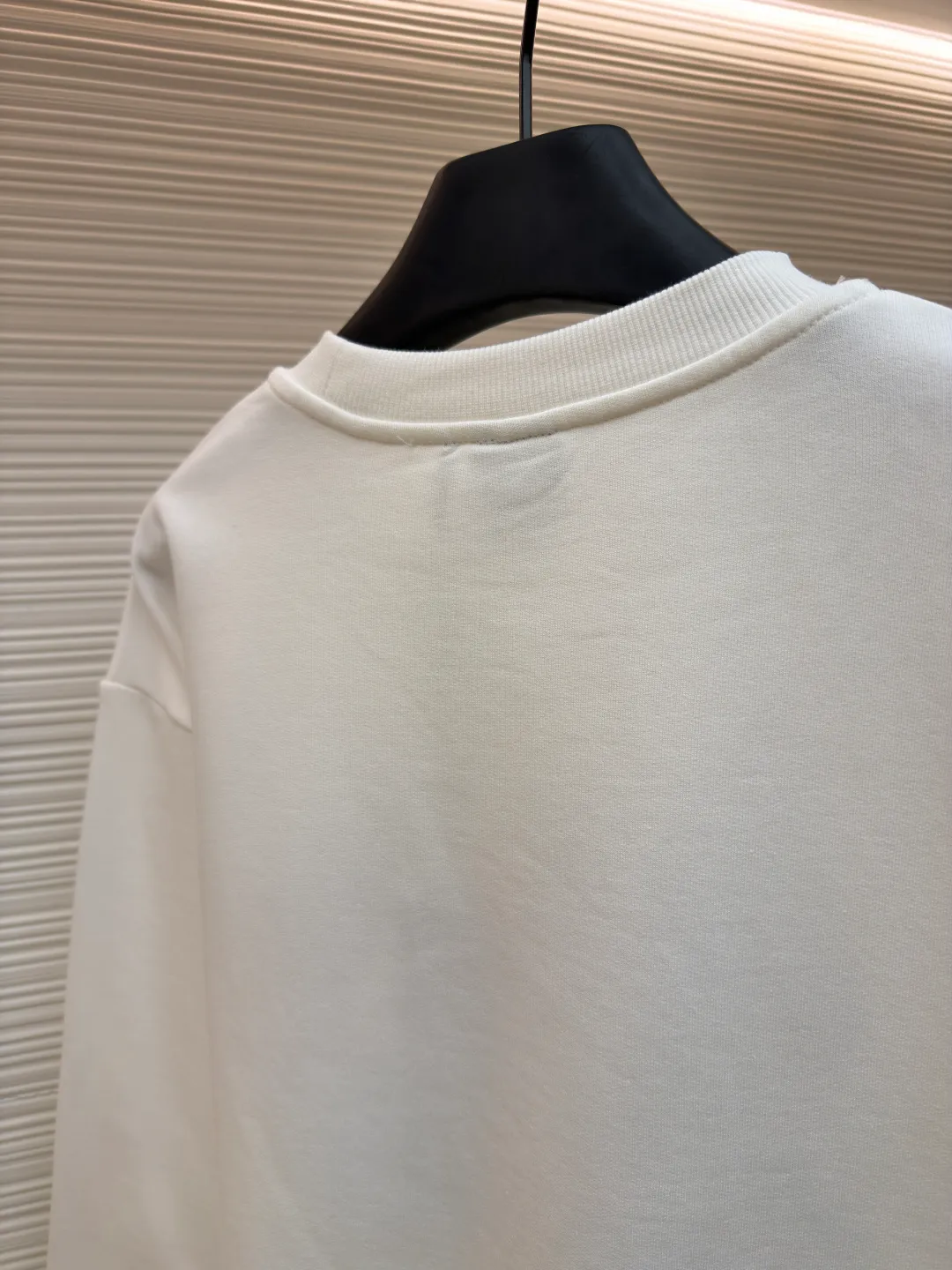 Dior four-leaf clover round neck sweatshirt ●Original version: purchased and developed by 19189 ●Item number: 1682447-A55 ●Material: pure cotton terry bottom sweatshirt fabric ●Technology: hollow embroidery production of coarse wool yarn ●Color: white ●Version: fitted version ●Weight: about 565 grams ●Size: XS-S-M-L ●Description: It adopts a fleece fabric structure of 26-count double yarn surface + 10-count yarn bottom, with a weight of 380g/㎡; with the same weight of 21-count 1x1 rib 470g/㎡. The 26-count double yarn forms a smooth and dense outer surface, and the 10-count yarn base is precisely brushed to form a rich and uniform velvet layer, thereby simultaneously achieving a crisp and skeletal feel on the outside and a skin-friendly touch like cloud velvet on the inside. Ribbing is used on the collar, cuffs and hem. Its extremely high weight and density ensure the ultimate thickness, resilience and deformation resistance of these closing parts, and together with the body, create a full and three-dimensional silhouette. The white color highlights the pure and delicate texture of the fabric and the pile loop texture on the bottom. The Dior Clover embroidery on the front uses hollow embroidery technology of coarse wool yarn. Refers to the use of special embroidery thread that is thicker and may have a plush texture. Its function is to give the embroidery pattern a unique fluffy, three-dimensional and soft touch, imitating the effect of wool weaving or tufting. This is an embroidery technique that uses specific stitches to make embroidery threads form an annular or hoop-like structure on the surface of the fabric. The embroidery thread does not adhere closely to the fabric, but forms tiny air circles, creating an extremely full, three-dimensional and elastic embroidery surface. The combination of the two creates a four-leaf clover pattern that is visually eye-catching, tactilely fluffy, and extremely handmade and artistic, forming a sharp and interesting contrast with the smooth white suede. The overall wiring is straight and delicate, the fabric is comfortable and soft, and the color is consistent without color difference. It can be matched with the same style to create a fashionable look and control various occasions. Customized accessories, complete with three standards, same style for men and women!