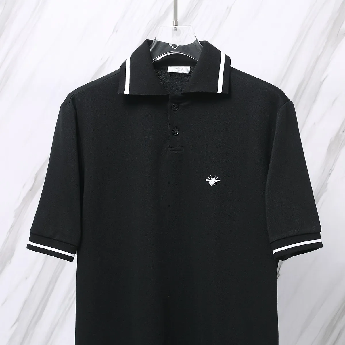 🅿️190 Item No. D41 (Dior classic little bee embroidered logo POLO shirt) Dior Dior 24ss new little bee letter embroidered logo lapel Polo shirt short-sleeved T-shirt. The counter restores the top replica for men and women. The own factory style is very good, business commuting, classic POLO lapel design, the classic small logo embroidery design on the chest highlights personality, making the entire line smoother, the most classic evergreen small logo design Exquisite embroidered logo design on the chest, pure cotton texture that is skin-friendly and comfortable. Suitable for both business and leisure. The piqué cotton fabric is more breathable and dry than ordinary knitted fabrics. 3D three-dimensional tailoring technology, the upper body is three-dimensional. The embroidery on the chest is full of details, and the embroidery with thousands of needles is three-dimensional and full. It is made of 240 grams of pure cotton piqué cotton fabric and customized buttons. Top quality product. Color: Black Size: S/M/L/XL