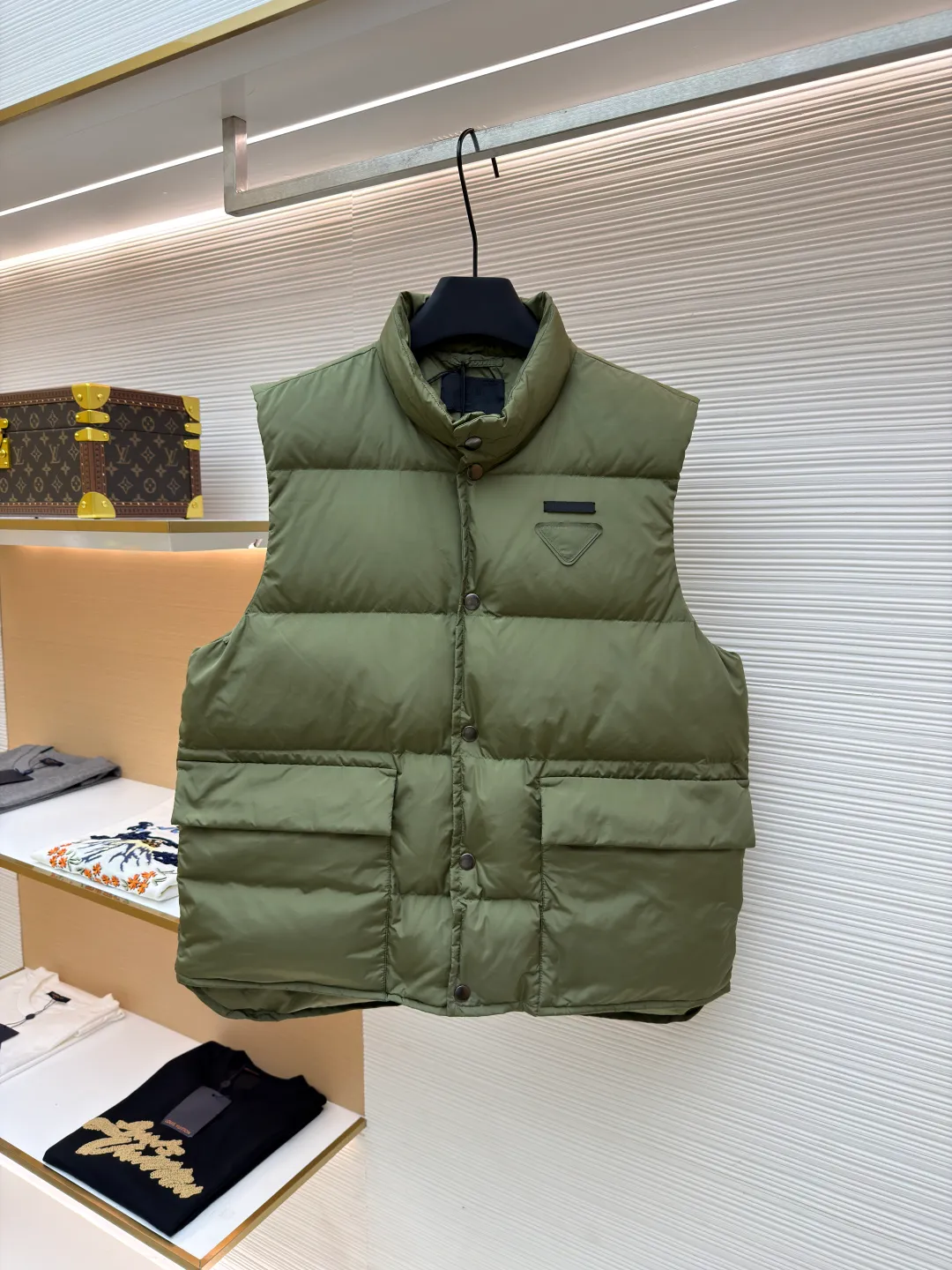PRADA fabric triangle down vest ●Original version: Purchased and developed by 11909 ●Item number: 1681118-C10 ●Fabric: white duck down fabric ●Technology: patch production ●Version: fitted version ●Weight: about 430 grams ●Size: 46-48-50-52 ●Description: The brand's iconic regenerated nylon fabric is selected, which has the same performance as traditional nylon, with high strength, tear resistance, wear resistance and other characteristics. It is lightweight and waterproof, suitable for various scenarios. Anti-wrinkle, quick-drying and easy to maintain on a daily basis. The felt cloth material is flatly fixed on the stamping machine table. Under the control of the ground controller, the upper mold is driven to move downward at extremely high speed and pressure. The sharp edge under pressure cuts off the felt cloth fibers instantly and cleanly like a paper knife. The whole process is completed within milliseconds. Through precise calculation, the triangle shape with no burrs and brushed edges is formed. It uses 90 white duck down with a weight of 160g to ensure excellent thermal insulation performance. After strict screening and processing, the velvet is not easy to drill, ensuring durability. The overall wiring is straight and delicate, the fabric is comfortable and soft, and the color is consistent without color difference. It can be matched with the same style to create a fashionable look and control various occasions. Customized accessories, complete with three standards, same style for men and women!