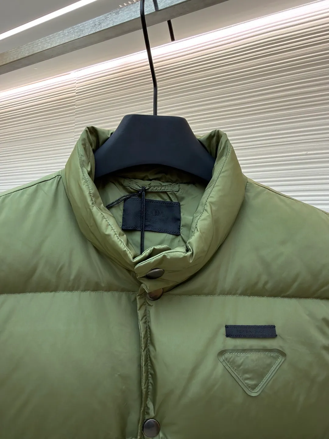 PRADA fabric triangle down vest ●Original version: Purchased and developed by 11909 ●Item number: 1681118-C10 ●Fabric: white duck down fabric ●Technology: patch production ●Version: fitted version ●Weight: about 430 grams ●Size: 46-48-50-52 ●Description: The brand's iconic regenerated nylon fabric is selected, which has the same performance as traditional nylon, with high strength, tear resistance, wear resistance and other characteristics. It is lightweight and waterproof, suitable for various scenarios. Anti-wrinkle, quick-drying and easy to maintain on a daily basis. The felt cloth material is flatly fixed on the stamping machine table. Under the control of the ground controller, the upper mold is driven to move downward at extremely high speed and pressure. The sharp edge under pressure cuts off the felt cloth fibers instantly and cleanly like a paper knife. The whole process is completed within milliseconds. Through precise calculation, the triangle shape with no burrs and brushed edges is formed. It uses 90 white duck down with a weight of 160g to ensure excellent thermal insulation performance. After strict screening and processing, the velvet is not easy to drill, ensuring durability. The overall wiring is straight and delicate, the fabric is comfortable and soft, and the color is consistent without color difference. It can be matched with the same style to create a fashionable look and control various occasions. Customized accessories, complete with three standards, same style for men and women!