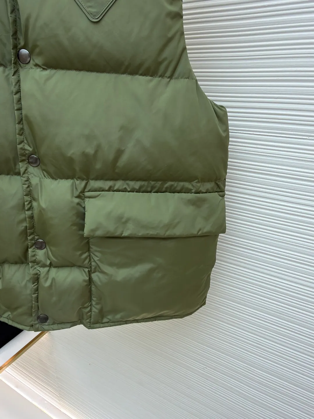 PRADA fabric triangle down vest ●Original version: Purchased and developed by 11909 ●Item number: 1681118-C10 ●Fabric: white duck down fabric ●Technology: patch production ●Version: fitted version ●Weight: about 430 grams ●Size: 46-48-50-52 ●Description: The brand's iconic regenerated nylon fabric is selected, which has the same performance as traditional nylon, with high strength, tear resistance, wear resistance and other characteristics. It is lightweight and waterproof, suitable for various scenarios. Anti-wrinkle, quick-drying and easy to maintain on a daily basis. The felt cloth material is flatly fixed on the stamping machine table. Under the control of the ground controller, the upper mold is driven to move downward at extremely high speed and pressure. The sharp edge under pressure cuts off the felt cloth fibers instantly and cleanly like a paper knife. The whole process is completed within milliseconds. Through precise calculation, the triangle shape with no burrs and brushed edges is formed. It uses 90 white duck down with a weight of 160g to ensure excellent thermal insulation performance. After strict screening and processing, the velvet is not easy to drill, ensuring durability. The overall wiring is straight and delicate, the fabric is comfortable and soft, and the color is consistent without color difference. It can be matched with the same style to create a fashionable look and control various occasions. Customized accessories, complete with three standards, same style for men and women!