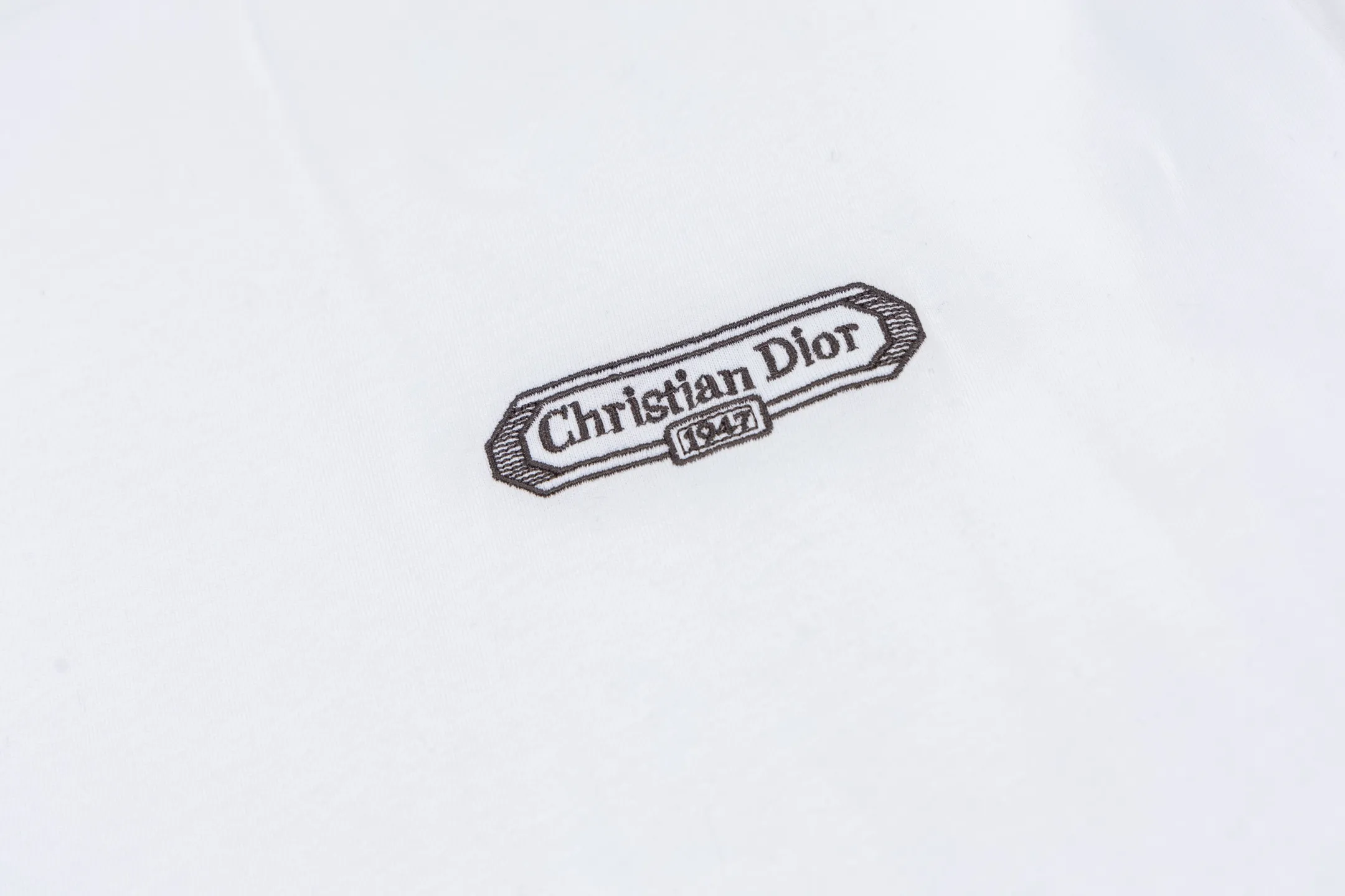 🅿️260 CD 25FW Logo Embroidered Short Sleeve The fabric is made of 24S 185g special woven compact cotton fabric, and the rib is made of 32S 300g double yarn rib. It is woven with 24 count special woven compact cotton yarn. The weaving process requires high standards and requires the use of advanced looms and high-quality raw materials. Specially woven compact cotton has many advantages, such as softness and comfort, good breathability, strong wrinkle resistance, good durability, etc.; it has a tighter, softer and more delicate texture and feel. Add exquisite details to soft fabrics through embroidery to enhance the sense of luxury; the needle-stitch embroidery process has unique style and characteristics. The number of times the stitches are repeated highlights the layering and delicacy. Needle embroidery can achieve very fine details, and the work has a strong sense of line and three-dimensionality. Size:XS-S-M-L