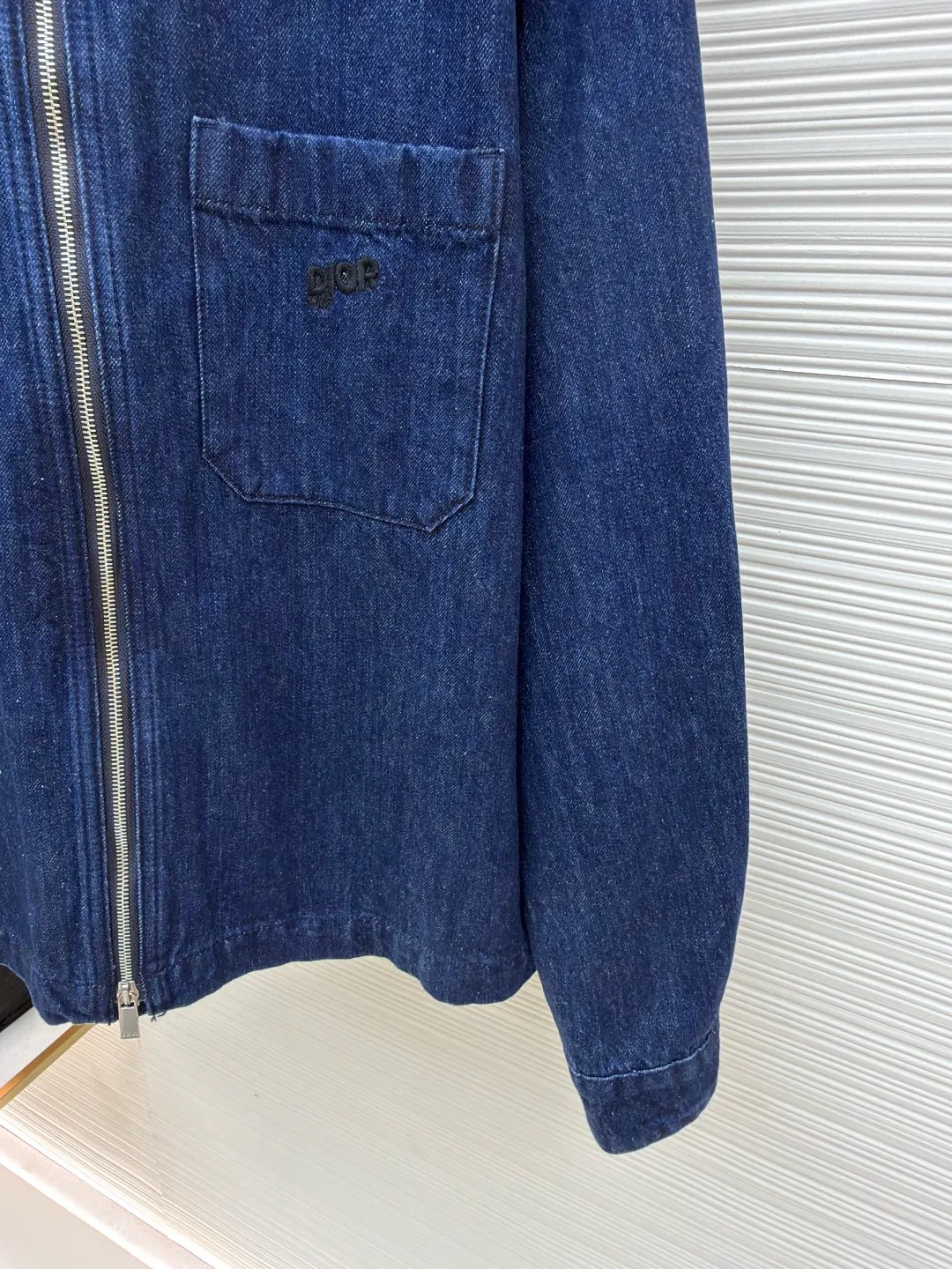 Dior black letter embroidered jacket denim shirt ●Original version: Purchased and developed by 12599 ●Item number: 1681538-B45 ●Material: denim fabric ●Technology: Soft washable production ●Color: blue ●Version: fitted version ●Weight: about 790 grams ●Size: 44-46-48-50 ●Description: This product is made of blue cotton denim. The fabric is woven using high-count cotton yarn. The finished garment effect is achieved through stone washing and finishing process. Special fabric treatments retain denim's classic look and durability while reducing its traditional heavy, stiff stereotype, making it more suitable as a spring outerwear shirt. The embroidery is applied to the breast pockets and back, using a process that combines black embroidery thread with flat stitch three-dimensional embroidery to present the delicate layers and outline lines of the letters. Its precise stitching creates a tense contrast with the rough texture of the jeans. The brand letter logo is matte and needle embroidered, and the contrasting matte embroidery thread material is used for the version to best restore the same effect as the original version. The embroidery is very fine and dense, and by controlling the direction and tightness of the embroidery thread, the embroidery thread forms different bends and heights on the embroidery cloth. Combined with encryption processing to increase the three-dimensional effect, it has a convex feel and a strong three-dimensional effect, and the embroidery body has a subtle matte visual texture. General washing is a common denim washing process, mainly used to remove impurities and floating colors on the surface of denim. In the general washing process, water and detergent are usually used for cleaning. Through gentle scrubbing and rinsing, the denim becomes softer and cleaner. The overall wiring is straight and delicate, the fabric is comfortable and soft, and the color is consistent without color difference. It can be matched with the same style to create a fashionable look and control various occasions. Customized accessories, complete with three standards, same style for men and women!