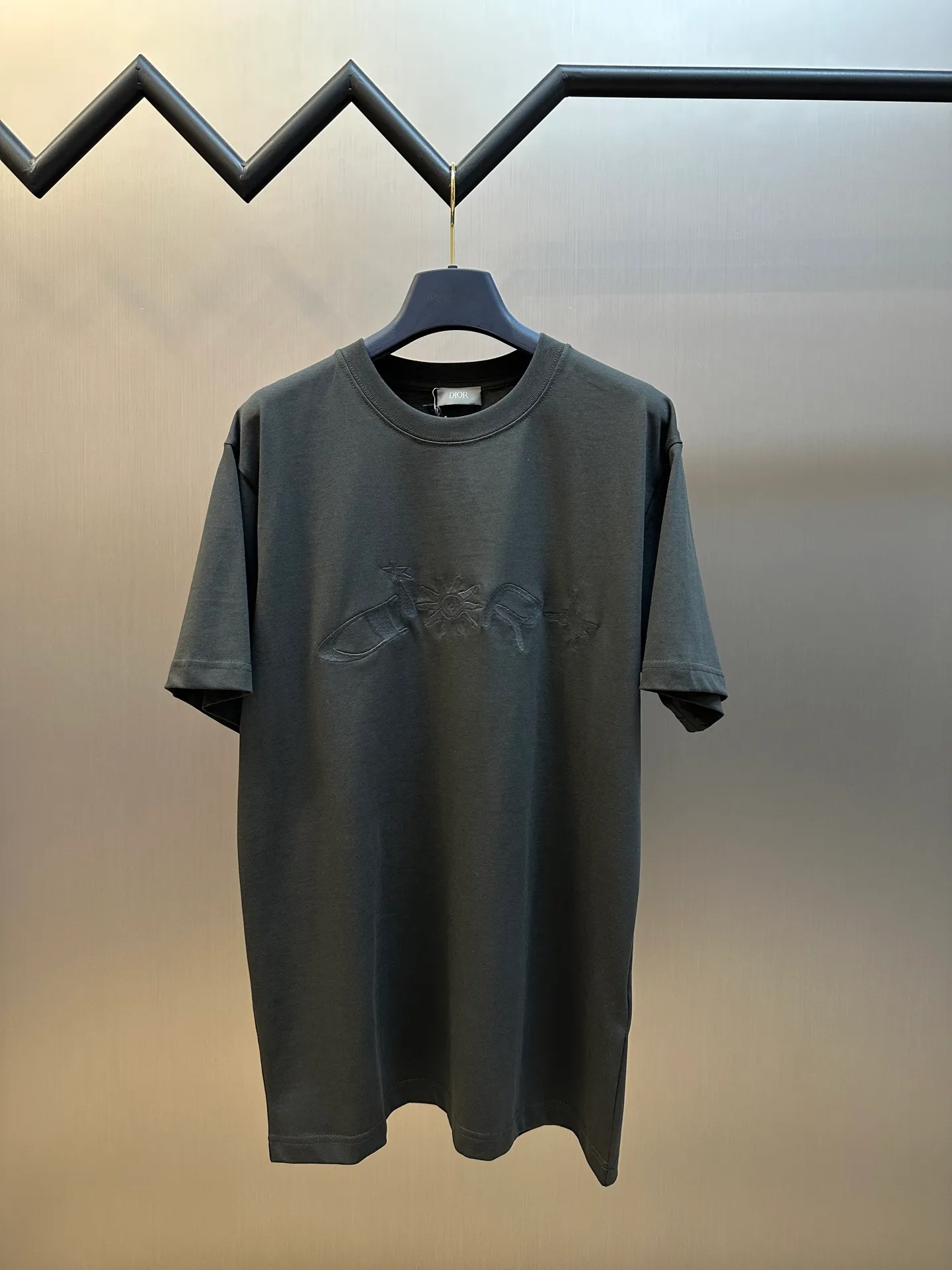 🅿️260 Dior co-branded embroidered round neck short-sleeved cotton jersey fabric, made of 15S fine cotton plain weave, 230g; paired with threaded 32S double yarn rack, 300g. 15S is a relatively thick yarn used to make thicker and more durable fabrics. The fabric made of pure cotton natural fiber has the characteristics of good hygroscopicity, strong breathability, softness and comfort. Cotton fabrics are generally suitable for summer wear and can help keep your body dry and comfortable. The yarn passes alternately in the horizontal and vertical directions to form a simple cross structure; it has good elasticity and wear resistance.  It is processed by needle embroidery process, and the main body adopts precision needle embroidery process; the embroidery is very fine and dense, the pattern is clear and the lines and three-dimensional sense are strong. The linen material embroidery thread is combined with encrypted processing, and the embroidery body has a subtle matte visual texture; the embroidery effect is three-dimensional and full. The flat embroidery has a unique needle-to-needle design, and the embroidery is very fine and dense. The overall stitching is fine, with consistent fineness and texture, adding a sense of layering to the simple design.  The standard round neck and short-sleeved version has a rounded arc neckline, which is suitable for various face shapes and body shapes; the sleeve length is moderate and ends just above the elbow, showing a smart and neat image. The slim fit can show off the wearer's body curves without sacrificing comfort. The collar, cuffs, hem and other parts are all sewn with fine double-needle stitching.  size：xs s m l