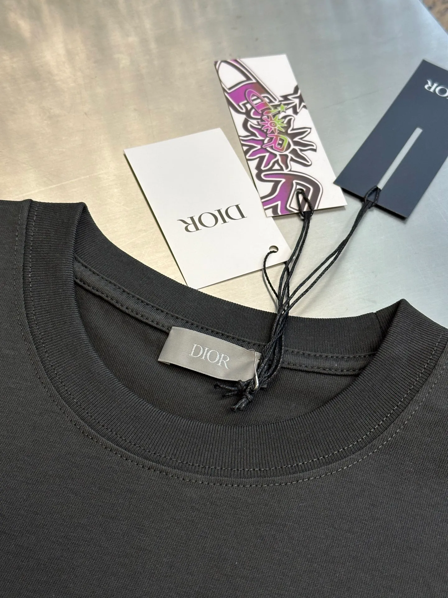 🅿️260 Dior co-branded embroidered round neck short-sleeved cotton jersey fabric, made of 15S fine cotton plain weave, 230g; paired with threaded 32S double yarn rack, 300g. 15S is a relatively thick yarn used to make thicker and more durable fabrics. The fabric made of pure cotton natural fiber has the characteristics of good hygroscopicity, strong breathability, softness and comfort. Cotton fabrics are generally suitable for summer wear and can help keep your body dry and comfortable. The yarn passes alternately in the horizontal and vertical directions to form a simple cross structure; it has good elasticity and wear resistance.  It is processed by needle embroidery process, and the main body adopts precision needle embroidery process; the embroidery is very fine and dense, the pattern is clear and the lines and three-dimensional sense are strong. The linen material embroidery thread is combined with encrypted processing, and the embroidery body has a subtle matte visual texture; the embroidery effect is three-dimensional and full. The flat embroidery has a unique needle-to-needle design, and the embroidery is very fine and dense. The overall stitching is fine, with consistent fineness and texture, adding a sense of layering to the simple design.  The standard round neck and short-sleeved version has a rounded arc neckline, which is suitable for various face shapes and body shapes; the sleeve length is moderate and ends just above the elbow, showing a smart and neat image. The slim fit can show off the wearer's body curves without sacrificing comfort. The collar, cuffs, hem and other parts are all sewn with fine double-needle stitching.  size：xs s m l