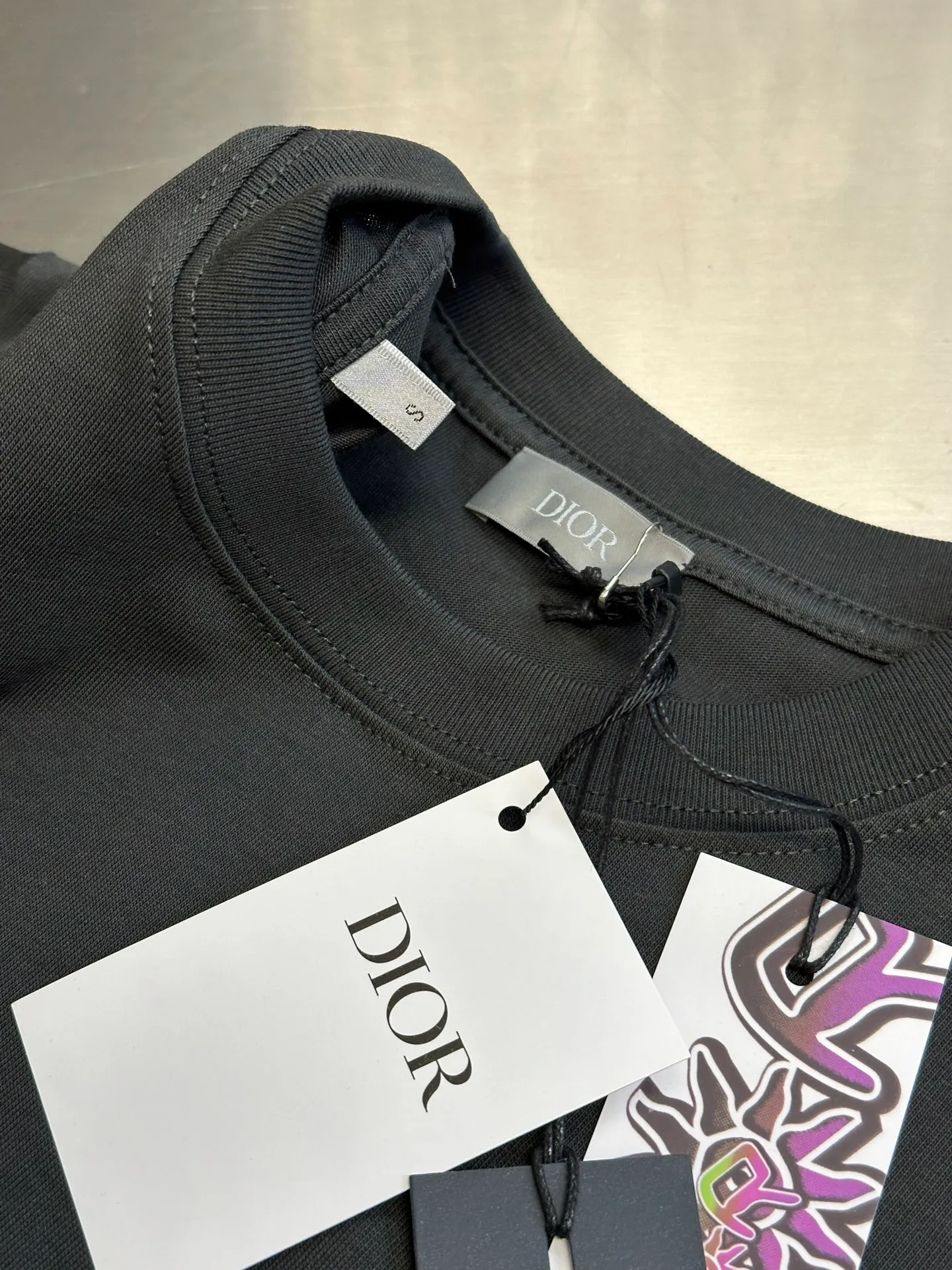 🅿️260 Dior co-branded embroidered round neck short-sleeved cotton jersey fabric, made of 15S fine cotton plain weave, 230g; paired with threaded 32S double yarn rack, 300g. 15S is a relatively thick yarn used to make thicker and more durable fabrics. The fabric made of pure cotton natural fiber has the characteristics of good hygroscopicity, strong breathability, softness and comfort. Cotton fabrics are generally suitable for summer wear and can help keep your body dry and comfortable. The yarn passes alternately in the horizontal and vertical directions to form a simple cross structure; it has good elasticity and wear resistance.  It is processed by needle embroidery process, and the main body adopts precision needle embroidery process; the embroidery is very fine and dense, the pattern is clear and the lines and three-dimensional sense are strong. The linen material embroidery thread is combined with encrypted processing, and the embroidery body has a subtle matte visual texture; the embroidery effect is three-dimensional and full. The flat embroidery has a unique needle-to-needle design, and the embroidery is very fine and dense. The overall stitching is fine, with consistent fineness and texture, adding a sense of layering to the simple design.  The standard round neck and short-sleeved version has a rounded arc neckline, which is suitable for various face shapes and body shapes; the sleeve length is moderate and ends just above the elbow, showing a smart and neat image. The slim fit can show off the wearer's body curves without sacrificing comfort. The collar, cuffs, hem and other parts are all sewn with fine double-needle stitching.  size：xs s m l