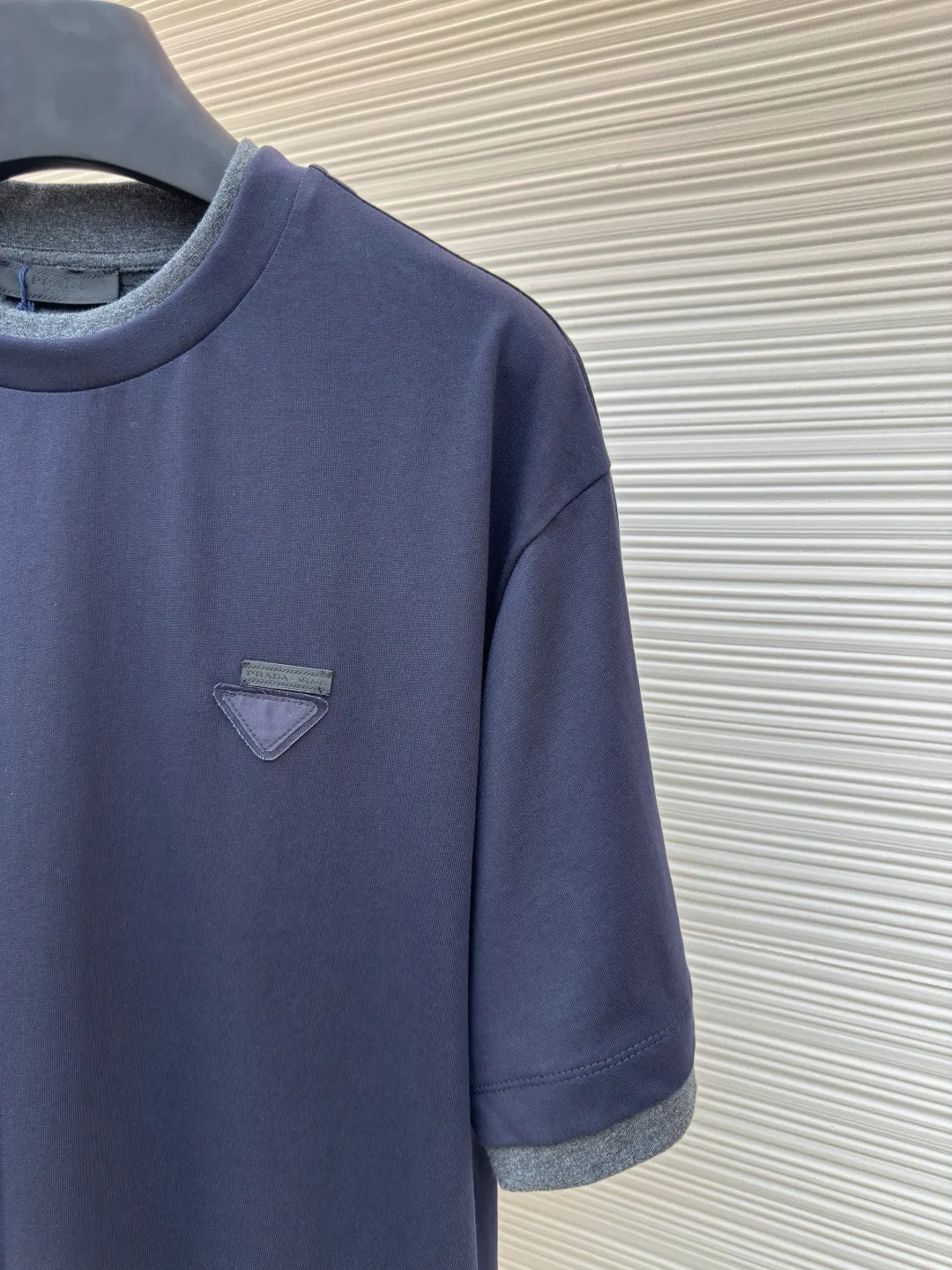 Prada triangular cloth label round neck short sleeves ●Authentic product: Purchased and developed by 4482 ●Item number: 1680227-A10 ●Fabric: special woven dense cotton fabric ●Technology: made on positioning cutting machine ●Version: fitted version ●Weight: about 260 grams ●Size: XS-S-M-L ●Description: Made of 24S special woven compact cotton fabric, 185g; with 40S double yarn thread, 220g. The strength of compact yarn is higher than that of traditional single yarn. The single fibers in compact yarn are closely arranged, which helps to improve the strength of the yarn. The ends of the fibers are all twisted into the yarn, so the yarn is very tight and the yarn has a smooth appearance with less hairiness. Compact spinning yarn has higher strength and less hairiness, making it less prone to fraying. The characteristics of the classic brand's triangular woven label are innovative breakthroughs from three dimensions: material collision, structural craftsmanship and symbolic narrative. The three-dimensional thickness is formed by hot-pressing composite. Because it can be woven with woven yarn raw materials, laser cut and restored, it has different characteristics in terms of temperature resistance. The classic round neck basic version design adopts a double-layer neckline and asymmetrical hem with a fake two-piece structure, and the side seams form a three-dimensional box silhouette. Create a visual dislocation effect through the collision and stacking of color blocks. The triangle logo on the front chest is heat-embossed to create a matte and slightly reflective contrast with the main fabric. The overall wiring is straight and delicate, the fabric is comfortable and soft, and the color is consistent without color difference. It can be matched with the same style to create a fashionable look and control various occasions. Customized accessories, complete with three standards, same style for men and women!