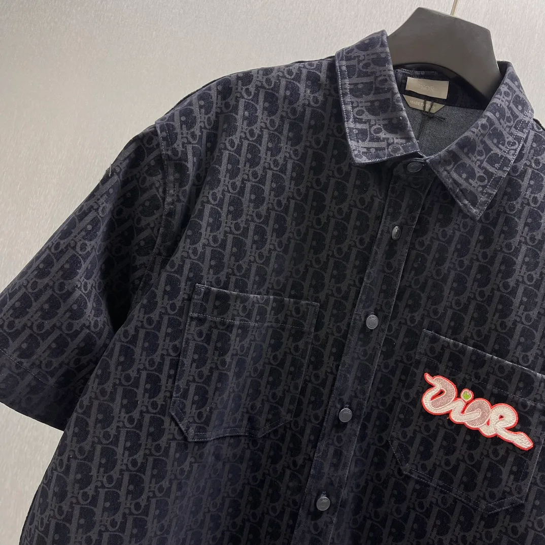 🅿️510 🧧CD all-over printed Year of the Snake embroidered short-sleeved shirt Size: S-XL This short-sleeved shirt is from Dior, and the overall color is dark blue. It is covered with the brand’s classic “CD” presbyopia pattern, highlighting brand recognition. There is an eye-catching "Dior" embroidered logo on the left breast pocket, which is brightly colored and adds highlights. The loose fit makes it comfortable to wear while still being fashionable, and is suitable for a variety of casual occasions.