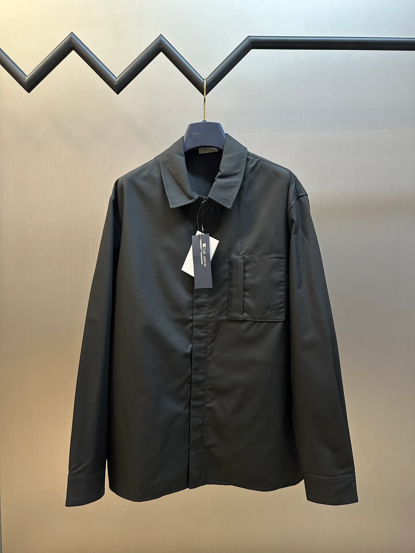 🅿️650 DIOR CD icon embroidered jacket is made of black gabardine fabric, with a smooth and delicate surface, soft touch, and elegant luster. Its tight textile construction makes it resistant to wrinkles, abrasion and drape. The wool component makes it warm and breathable. Gabardine fabric is not easy to pill, has good stain resistance, and is easy to care for daily.  The modern fit has a slim fit and a hidden zip closure adds understated sophistication. High-precision sewing technology ensures a perfect fit between the zipper and the fabric. The lapel design of traditional shirts still meets the needs of formal occasions. There is a patch pocket on the chest and is decorated with CD icon embroidery, which highlights the brand's iconic elements. The bag opening also has a hidden zipper opening, and the bag opening is reinforced with pocket knotting technology at the beginning and end. Tight stitching at the edge of the bag body makes it strong and beautiful. There are side pockets on the left and right sides, and the pocket openings are only 0.5 cm hemmed, which retains the smoothness of the overall lines without losing practicality. The double-button design of traditional shirt cuffs makes the cuffs fit more closely on the wrist and prevent them from loosening.  size：s m l xl