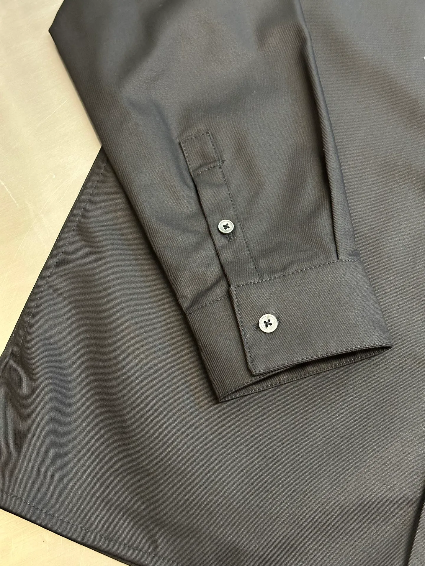 🅿️650 DIOR CD icon embroidered jacket is made of black gabardine fabric, with a smooth and delicate surface, soft touch, and elegant luster. Its tight textile construction makes it resistant to wrinkles, abrasion and drape. The wool component makes it warm and breathable. Gabardine fabric is not easy to pill, has good stain resistance, and is easy to care for daily.  The modern fit has a slim fit and a hidden zip closure adds understated sophistication. High-precision sewing technology ensures a perfect fit between the zipper and the fabric. The lapel design of traditional shirts still meets the needs of formal occasions. There is a patch pocket on the chest and is decorated with CD icon embroidery, which highlights the brand's iconic elements. The bag opening also has a hidden zipper opening, and the bag opening is reinforced with pocket knotting technology at the beginning and end. Tight stitching at the edge of the bag body makes it strong and beautiful. There are side pockets on the left and right sides, and the pocket openings are only 0.5 cm hemmed, which retains the smoothness of the overall lines without losing practicality. The double-button design of traditional shirt cuffs makes the cuffs fit more closely on the wrist and prevent them from loosening.  size：s m l xl