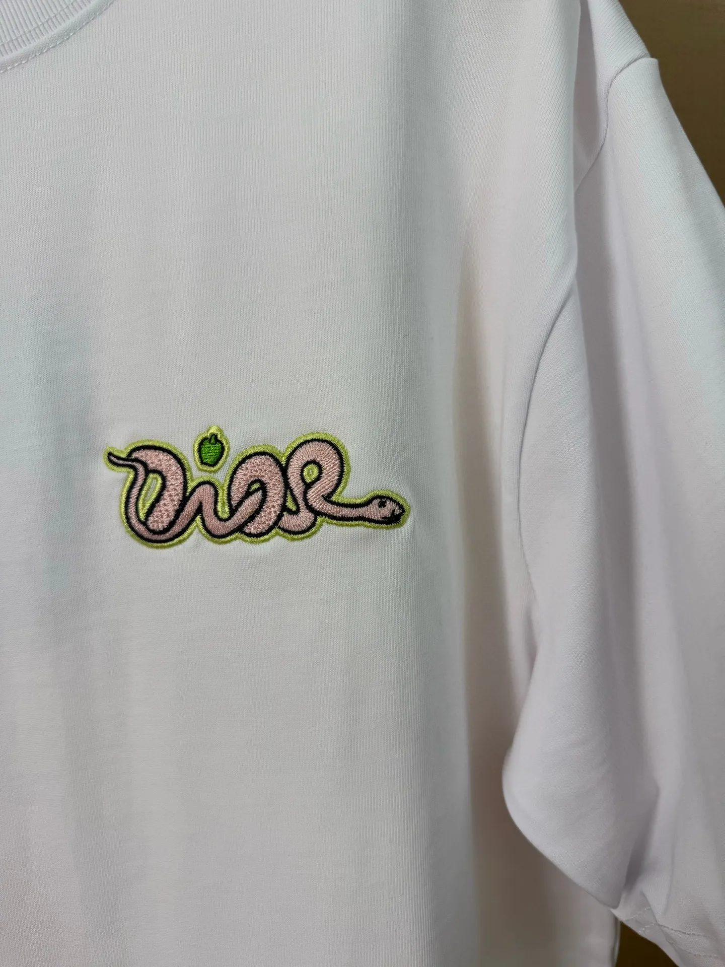 🅿️156 Dior Year of the Snake Limited Edition Apple Snake Embroidered Badge Short Sleeve Made of pure cotton 12S fine cotton plain fabric, 310g. The embroidery pattern is based on tatami embroidery technology. The embroidery uses a special single-needle arrangement. The stitches are tight and flat, forming a texture similar to the tatami grid, making the embroidery pattern have a strong three-dimensional and layered feel. Embroidered with silk threads of multiple colors, the colors are bright and contrasting, showing rich patterns and details. The outline is stroked by needle embroidery, the embroidery pattern is matched with the brand logo design, and the brand letter logo is single-needle flat embroidered. Made from a variety of needlework; the outline of the pattern is embroidered with a single straight line and straight silk thread. The outline edges and letter embroidery are stitched together to create clear and rich three-dimensional layers. The standard round neck and short-sleeved version has a rounded arc neckline, which is suitable for various face shapes and body shapes; the sleeve length is moderate and ends just above the elbow, showing a smart and neat image. The slim fit can show off the wearer's body curves without sacrificing comfort. The collar, cuffs, hem and other parts are all sewn with fine double-needle stitching. Size: S-XL
