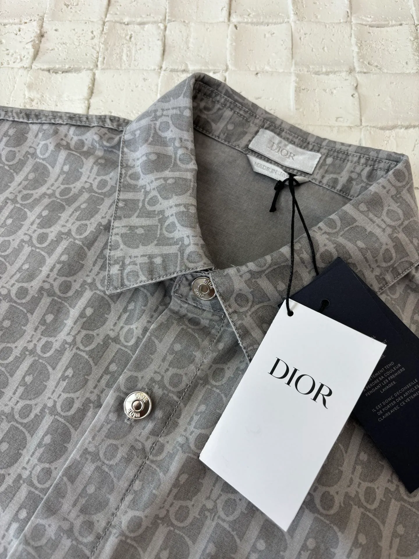 🅿️450 Dio*/Dior 25SS full-print jacquard short-sleeved shirt. The fabric letters are printed using a discharge printing process. The color of the original yarn is pulled out to white gray. It is not the so-called printed or jacquard fabric on the market. The fabric texture is thick and stiff, and it is not the soft and light material on the market. Pay attention to the distinction. The fabric characteristics are not easy to wrinkle. The dyeing yarn 100% restores the original color. Exclusively molded and custom-made aluminum buckles, which will not rust easily after being stored for a long time after washing. The letters "D1OR" on the small button on the pocket are clearly visible. The unique design of the notched lapels and the straight and loose fit not only retains the classic beauty of the lapels, but also gives the shirt a retro and casual atmosphere. A full set of new accessories are customized simultaneously, with perfect details. Size: 38/39/40/41