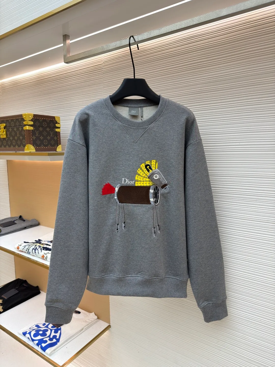 Dior horse embroidery round neck sweatshirt ●Original version: purchased and developed by 13941 ●Item number: 1682562-A70 ●Fabric: cotton fleece fabric ●Technology: embroidery production ●Color: gray ●Version: fitted version ●Weight: about 590 grams ●Size: XS-S-M-L ●Description: This product adopts a terry fabric structure of 26-count double yarn surface + 10-count yarn base, with a weight of 380g/㎡; the matching 21-count 1x1 rib also weighs 470g/㎡, and is used for the collar, cuffs and hem, and is a heavyweight sweatshirt fabric. The 26-count double yarn forms a smooth and delicate outer surface of the fabric, ensuring good color fastness. The 10-count yarn base is precision brushed to form a layer of rich, dense skin-friendly velvet on the inside of the fabric, providing excellent warmth and soft wrapping. The extremely high weight of the rib ensures the ultimate thickness, stiffness and deformation resistance of these closing parts; together with the body, it builds a full three-dimensional silhouette, and the gray color highlights the texture and high-end sense of the fabric. Environmentally friendly elastic glue printing: Printing the background of the pony pattern. This printing process is characterized by bright colors, strong coverage, and the elastic glue can stretch with the fabric without cracking, and the touch is relatively soft. Its function is to provide a large-area, flat color base and design framework for the entire pattern. Needle embroidery achieves three-dimensional reshaping of the pattern by superimposing high-density straight stitches on the printing base. It uses multi-color embroidery thread at an extreme density to continuously fill the outline and structure, accurately shaping the image and completing the color transition by changing threads. The overall wiring is straight and delicate, the fabric is comfortable and soft, and the color is consistent without color difference. It can be matched with the same style to create a fashionable look and control various occasions. Customized accessories, complete with three standards, same style for men and women!