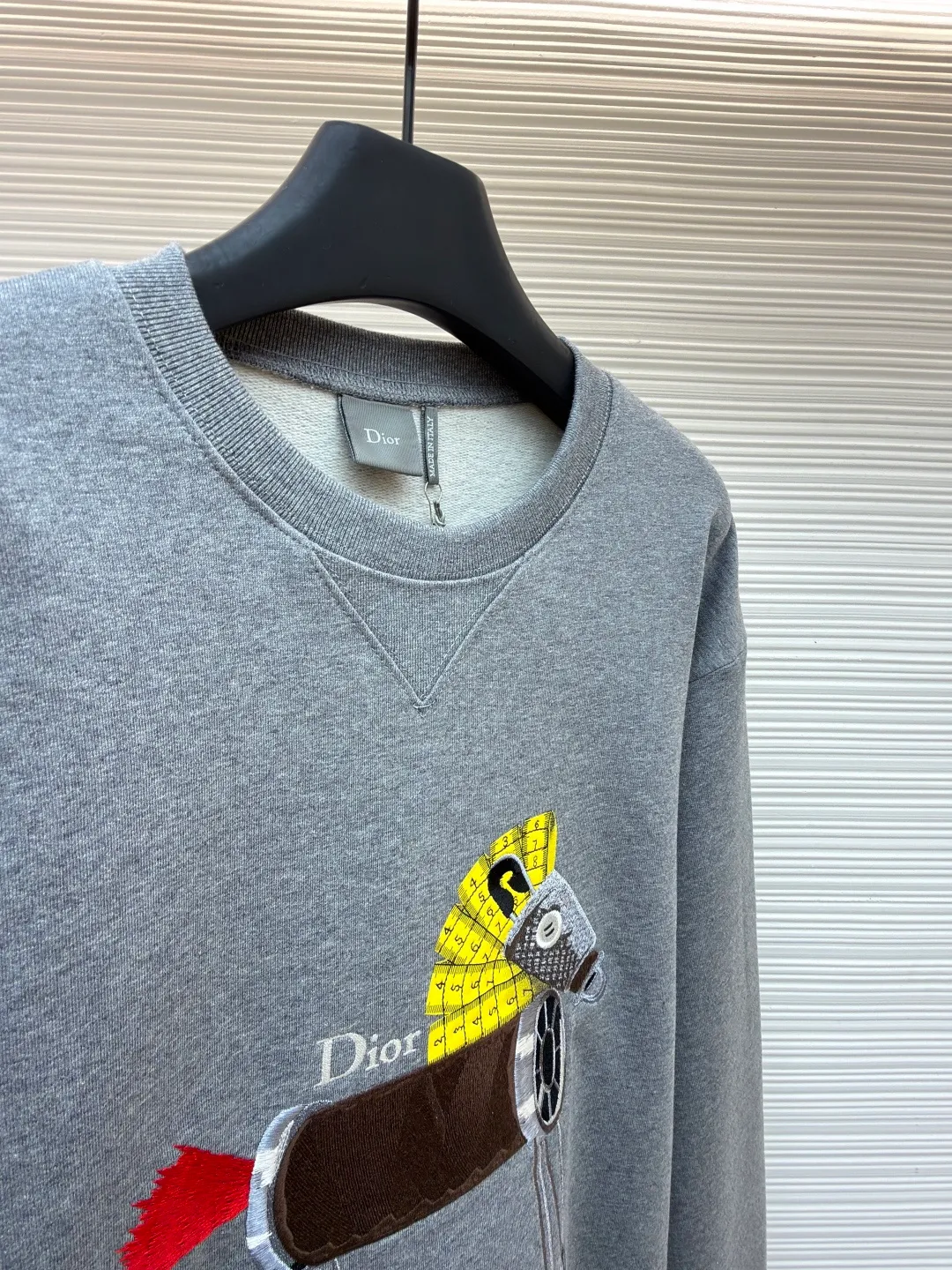 Dior horse embroidery round neck sweatshirt ●Original version: purchased and developed by 13941 ●Item number: 1682562-A70 ●Fabric: cotton fleece fabric ●Technology: embroidery production ●Color: gray ●Version: fitted version ●Weight: about 590 grams ●Size: XS-S-M-L ●Description: This product adopts a terry fabric structure of 26-count double yarn surface + 10-count yarn base, with a weight of 380g/㎡; the matching 21-count 1x1 rib also weighs 470g/㎡, and is used for the collar, cuffs and hem, and is a heavyweight sweatshirt fabric. The 26-count double yarn forms a smooth and delicate outer surface of the fabric, ensuring good color fastness. The 10-count yarn base is precision brushed to form a layer of rich, dense skin-friendly velvet on the inside of the fabric, providing excellent warmth and soft wrapping. The extremely high weight of the rib ensures the ultimate thickness, stiffness and deformation resistance of these closing parts; together with the body, it builds a full three-dimensional silhouette, and the gray color highlights the texture and high-end sense of the fabric. Environmentally friendly elastic glue printing: Printing the background of the pony pattern. This printing process is characterized by bright colors, strong coverage, and the elastic glue can stretch with the fabric without cracking, and the touch is relatively soft. Its function is to provide a large-area, flat color base and design framework for the entire pattern. Needle embroidery achieves three-dimensional reshaping of the pattern by superimposing high-density straight stitches on the printing base. It uses multi-color embroidery thread at an extreme density to continuously fill the outline and structure, accurately shaping the image and completing the color transition by changing threads. The overall wiring is straight and delicate, the fabric is comfortable and soft, and the color is consistent without color difference. It can be matched with the same style to create a fashionable look and control various occasions. Customized accessories, complete with three standards, same style for men and women!