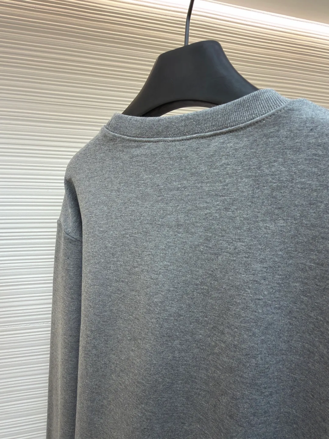 Dior horse embroidery round neck sweatshirt ●Original version: purchased and developed by 13941 ●Item number: 1682562-A70 ●Fabric: cotton fleece fabric ●Technology: embroidery production ●Color: gray ●Version: fitted version ●Weight: about 590 grams ●Size: XS-S-M-L ●Description: This product adopts a terry fabric structure of 26-count double yarn surface + 10-count yarn base, with a weight of 380g/㎡; the matching 21-count 1x1 rib also weighs 470g/㎡, and is used for the collar, cuffs and hem, and is a heavyweight sweatshirt fabric. The 26-count double yarn forms a smooth and delicate outer surface of the fabric, ensuring good color fastness. The 10-count yarn base is precision brushed to form a layer of rich, dense skin-friendly velvet on the inside of the fabric, providing excellent warmth and soft wrapping. The extremely high weight of the rib ensures the ultimate thickness, stiffness and deformation resistance of these closing parts; together with the body, it builds a full three-dimensional silhouette, and the gray color highlights the texture and high-end sense of the fabric. Environmentally friendly elastic glue printing: Printing the background of the pony pattern. This printing process is characterized by bright colors, strong coverage, and the elastic glue can stretch with the fabric without cracking, and the touch is relatively soft. Its function is to provide a large-area, flat color base and design framework for the entire pattern. Needle embroidery achieves three-dimensional reshaping of the pattern by superimposing high-density straight stitches on the printing base. It uses multi-color embroidery thread at an extreme density to continuously fill the outline and structure, accurately shaping the image and completing the color transition by changing threads. The overall wiring is straight and delicate, the fabric is comfortable and soft, and the color is consistent without color difference. It can be matched with the same style to create a fashionable look and control various occasions. Customized accessories, complete with three standards, same style for men and women!