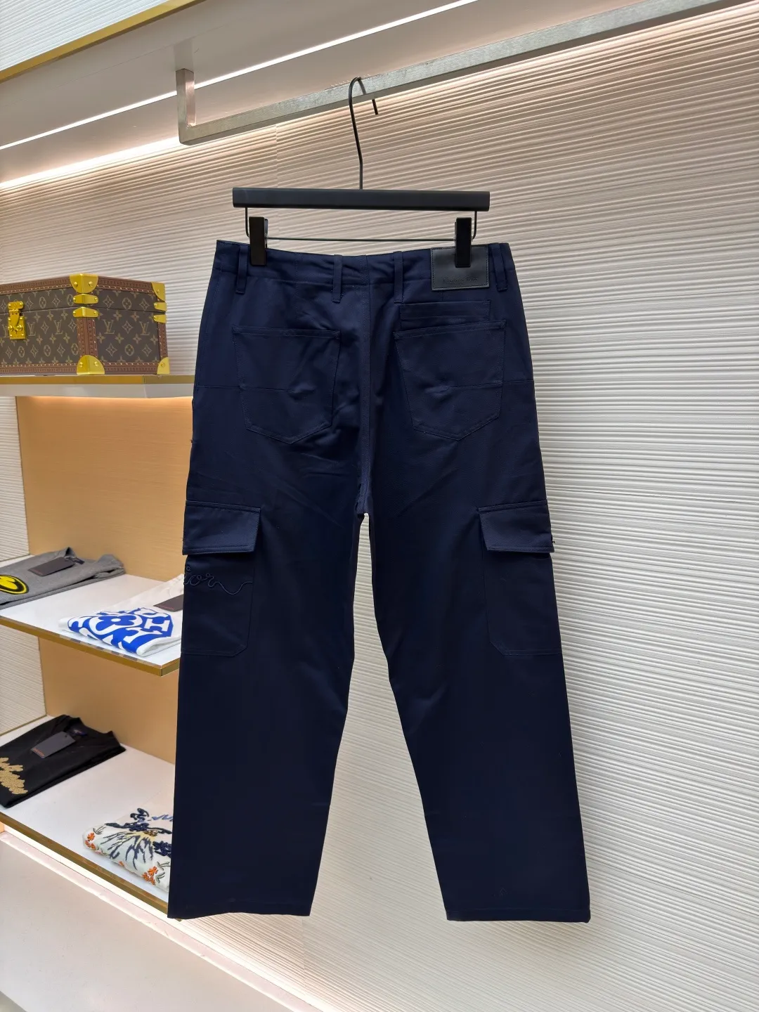 Dior cotton Huardani overalls ●Original version: purchased and developed by 12072 ●Item number: 1682111-B05 ●Fabric: 100% cotton ●Technology: Made on positioning cutting machine ●Color: navy blue ●Version: fitted version ●Weight: about 540 grams ●Size: 46-48-50-52-54-56 ●Description: This Dior SS26 spring men's overalls are made of high-count combed cotton twill fabric. The fabric has been enzyme washed and pre-shrunk to form a crisp and soft texture, and is anti-wrinkle and wear-resistant. The cargo pockets on both sides of the trousers adopt a three-dimensional patch pocket design. The pocket is equipped with a metal zipper. The zipper teeth are treated with electroplating and polishing processes, making them smooth and easy to pull and not easy to oxidize. The bag body is reinforced with double-lane stitching to increase the load-bearing capacity. The waist is equipped with a belt loop and adjustable buckle design. The belt loop is edged with the same fabric, and the buckle is made of alloy material and treated with matte sandblasting, giving it a high-end texture. The crotch adopts classic cross-reinforced stitching, the trousers are hemmed and hemmed, and the overall cut is a straight silhouette. Every splicing is precisely patterned and aligned, and the stitching is neat and detailed, perfectly integrating the practicality of workwear with the craftsmanship aesthetics of Dior's advanced men's wear. The overall wiring is straight and delicate, the fabric is comfortable and soft, and the color is consistent without color difference. It can be matched with the same style to create a fashionable look and control various occasions. Customized accessories, complete with three standards, same style for men and women!