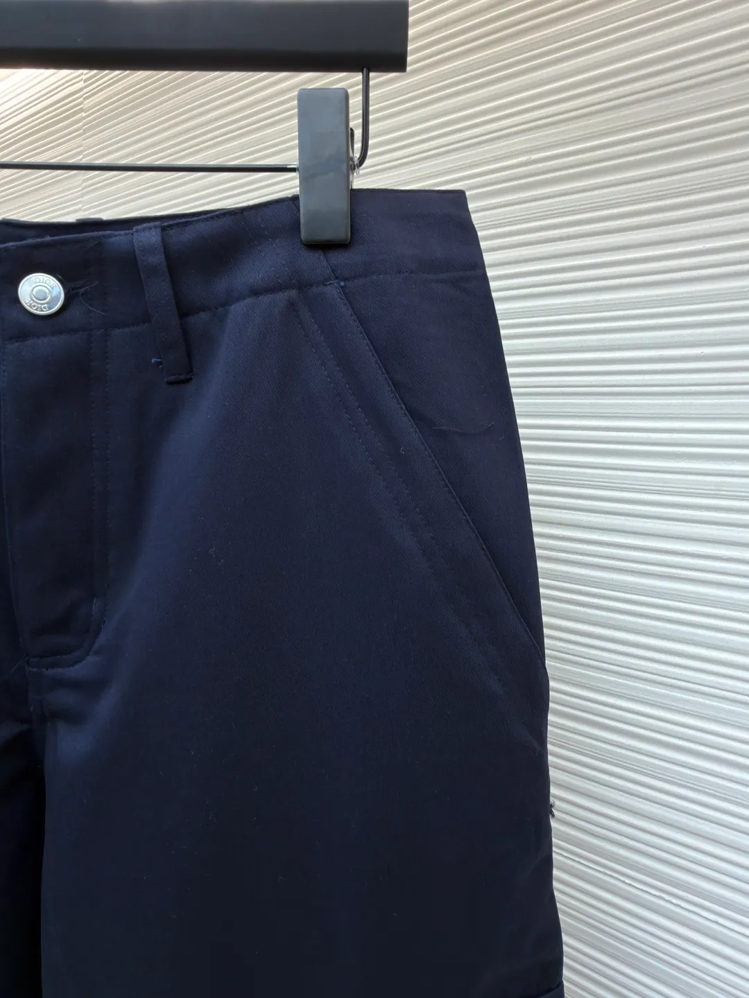 Dior cotton Huardani overalls ●Original version: purchased and developed by 12072 ●Item number: 1682111-B05 ●Fabric: 100% cotton ●Technology: Made on positioning cutting machine ●Color: navy blue ●Version: fitted version ●Weight: about 540 grams ●Size: 46-48-50-52-54-56 ●Description: This Dior SS26 spring men's overalls are made of high-count combed cotton twill fabric. The fabric has been enzyme washed and pre-shrunk to form a crisp and soft texture, and is anti-wrinkle and wear-resistant. The cargo pockets on both sides of the trousers adopt a three-dimensional patch pocket design. The pocket is equipped with a metal zipper. The zipper teeth are treated with electroplating and polishing processes, making them smooth and easy to pull and not easy to oxidize. The bag body is reinforced with double-lane stitching to increase the load-bearing capacity. The waist is equipped with a belt loop and adjustable buckle design. The belt loop is edged with the same fabric, and the buckle is made of alloy material and treated with matte sandblasting, giving it a high-end texture. The crotch adopts classic cross-reinforced stitching, the trousers are hemmed and hemmed, and the overall cut is a straight silhouette. Every splicing is precisely patterned and aligned, and the stitching is neat and detailed, perfectly integrating the practicality of workwear with the craftsmanship aesthetics of Dior's advanced men's wear. The overall wiring is straight and delicate, the fabric is comfortable and soft, and the color is consistent without color difference. It can be matched with the same style to create a fashionable look and control various occasions. Customized accessories, complete with three standards, same style for men and women!
