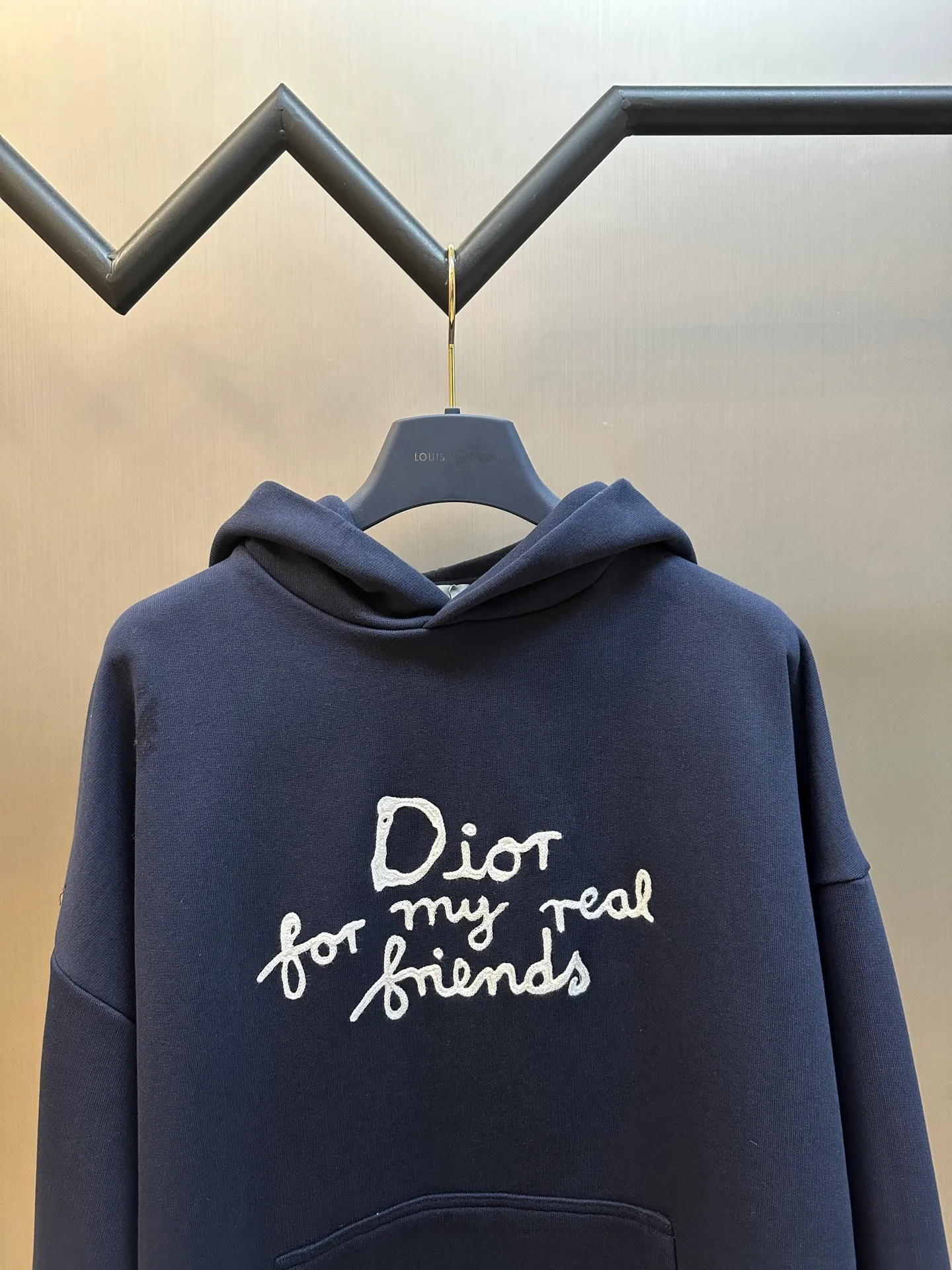 🅿️500 Dior Friends letter embroidered hooded sweatshirt. Cotton fleece fish scale bottom fabric. The surface of the 32-count double-yarn woven fabric is fine and tight, and it feels soft and comfortable. The weight of 50g and the bottom design of 10-count yarn make the fabric have good warmth retention and durability. Thanks to the relatively fine yarns used, this sweatshirt fabric is soft to the touch and comfortable to wear. The design of the fish scale base also increases the skin-friendliness of the fabric, making the wearing experience better. This fabric maintains softness while also possessing good wear-resistance and wrinkle-resistance.  The joint series logo is chain embroidery. Chain embroidery is named because the visual effect of the embroidery is like a chain. The shape is like the links on the chain. It is commonly known as chain embroidery and also called chain eye embroidery. Follow the chain stitch stitch method and embroider from right to left. Maintain the tension of the embroidery thread and the uniformity of the stitches to ensure the three-dimensionality and exquisiteness of the embroidery. It combines the stitching method of chain embroidery with the material of fine wool to create embroidery with chain-like texture and three-dimensional effect.  The hooded drop-shoulder is a loose fit, because it is quite loosely cut, and the shoulder line is large. The drop-shoulder design has no limit on shoulder width. The hem and cuffs are spliced ​​with ribs, which can provide wind protection; the hooded sweatshirt maintains a certain degree of looseness while maintaining a slim fit. The length of the sweatshirt is moderate, which can show the curves of the figure and present an elegant and fashionable feeling.  size：xs s m l