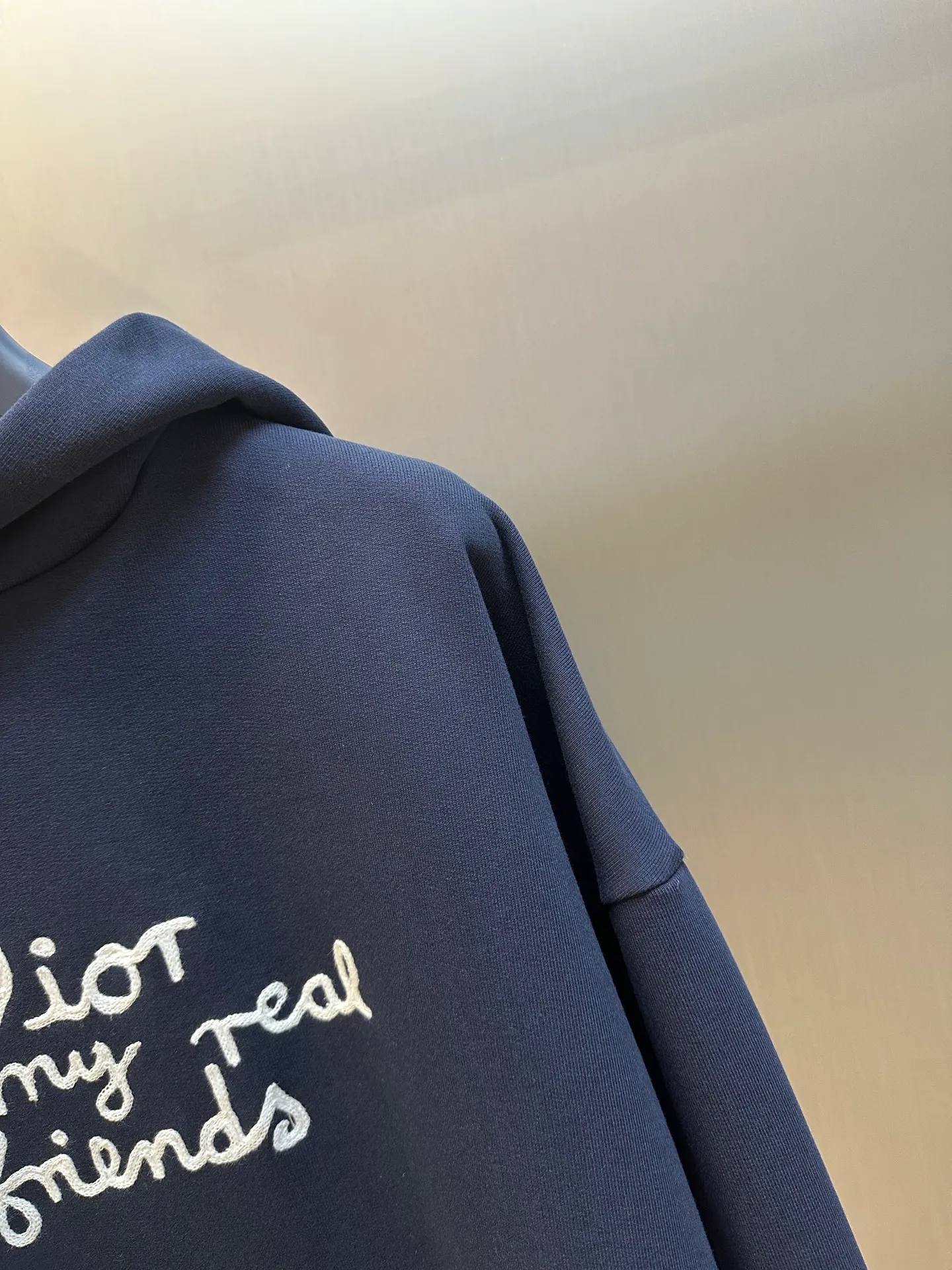 🅿️500 Dior Friends letter embroidered hooded sweatshirt. Cotton fleece fish scale bottom fabric. The surface of the 32-count double-yarn woven fabric is fine and tight, and it feels soft and comfortable. The weight of 50g and the bottom design of 10-count yarn make the fabric have good warmth retention and durability. Thanks to the relatively fine yarns used, this sweatshirt fabric is soft to the touch and comfortable to wear. The design of the fish scale base also increases the skin-friendliness of the fabric, making the wearing experience better. This fabric maintains softness while also possessing good wear-resistance and wrinkle-resistance.  The joint series logo is chain embroidery. Chain embroidery is named because the visual effect of the embroidery is like a chain. The shape is like the links on the chain. It is commonly known as chain embroidery and also called chain eye embroidery. Follow the chain stitch stitch method and embroider from right to left. Maintain the tension of the embroidery thread and the uniformity of the stitches to ensure the three-dimensionality and exquisiteness of the embroidery. It combines the stitching method of chain embroidery with the material of fine wool to create embroidery with chain-like texture and three-dimensional effect.  The hooded drop-shoulder is a loose fit, because it is quite loosely cut, and the shoulder line is large. The drop-shoulder design has no limit on shoulder width. The hem and cuffs are spliced ​​with ribs, which can provide wind protection; the hooded sweatshirt maintains a certain degree of looseness while maintaining a slim fit. The length of the sweatshirt is moderate, which can show the curves of the figure and present an elegant and fashionable feeling.  size：xs s m l