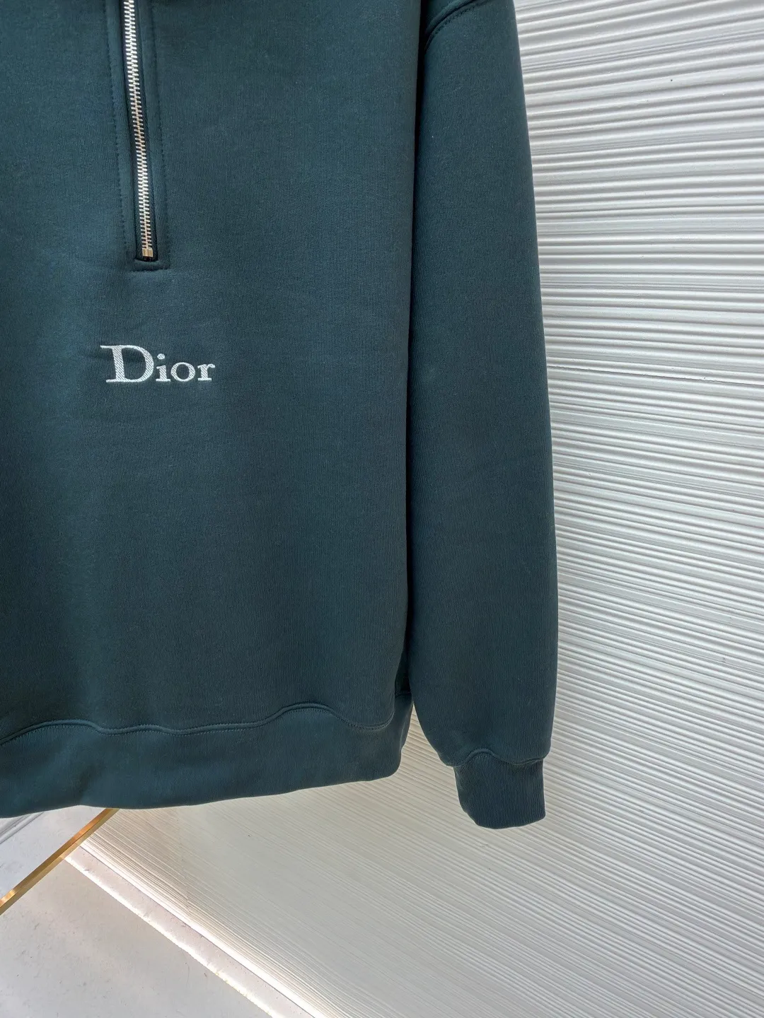 Dior half-zip logo sweatshirt ●Original version: 14,000 purchased and developed ●Item number: 1682498-A95 ●Material: pure cotton plush fabric ●Technology: twill logo embroidery production ●Color: green ●Version: fitted version ●Weight: about 685 grams ●Size: XS-S-M-L ●Description: The fabric is a heavyweight high-end sweatshirt fabric. The 26-count double yarn forms the smooth and delicate outer surface of the fabric, while the 10-count plush yarn base is precision brushed to form a layer of rich, dense skin-friendly fluff, providing excellent softness and warmth. Its extremely high weight and elasticity brought by spandex ensure the ultimate thickness, stiffness and strong elastic recovery of the collar, cuffs and hem, which is the key to creating a neat silhouette and ensuring durability. Made of twill flat stitch embroidery. This is an embroidery technique that uses parallel stitches at specific angles to fill in, creating a flat, smooth and full embroidery surface with fine diagonal texture. The brand logo is presented in a delicate, strong and textured way, and the precision of the embroidery creates a high-end contrast with the casual feel of the sweatshirt fabric. The overall wiring is straight and delicate, the fabric is comfortable and soft, and the color is consistent without color difference. It can be matched with the same style to create a fashionable look and control various occasions. Customized accessories, complete with three standards, same style for men and women!