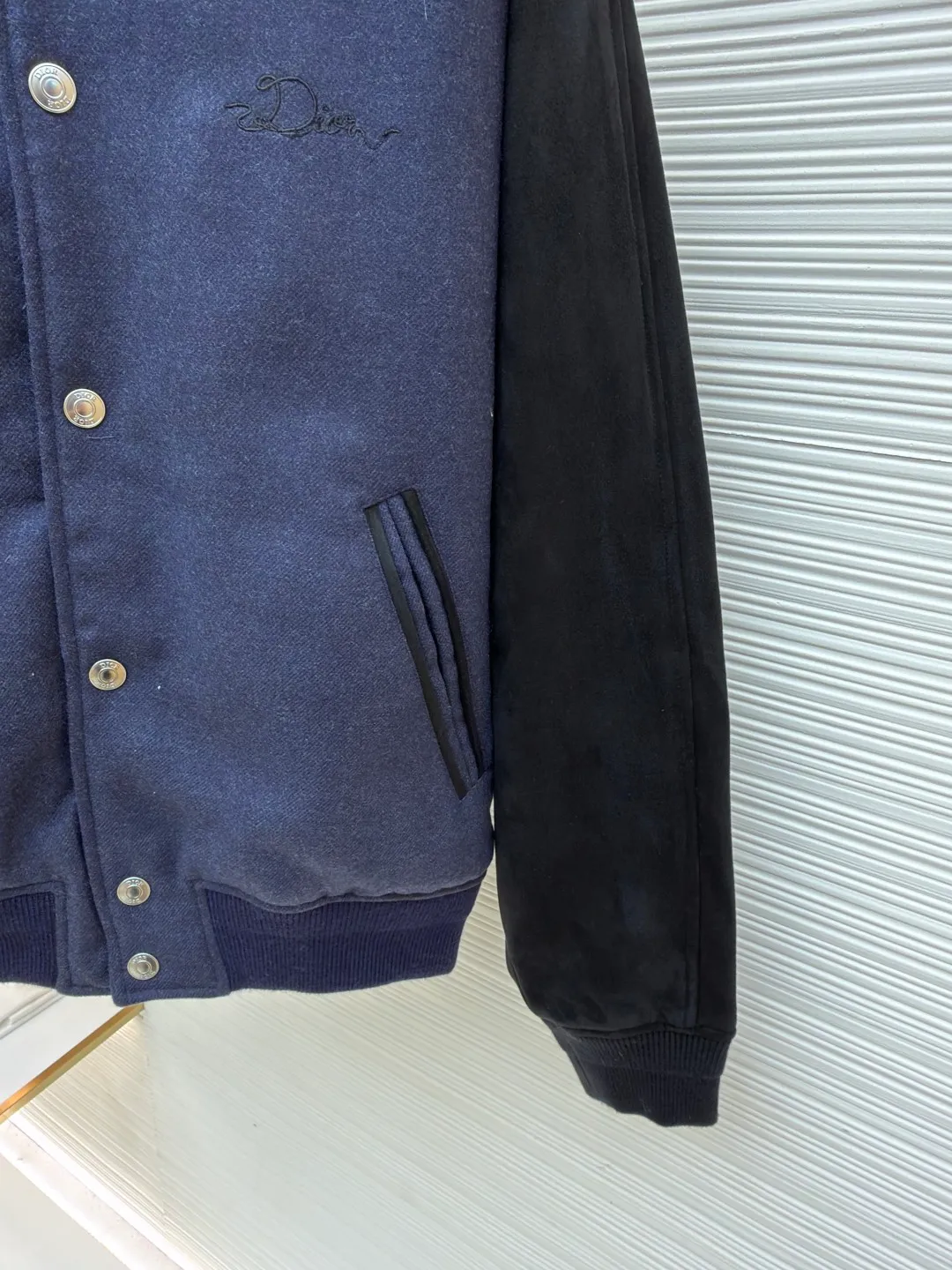 Dior embroidered baseball jacket ●Original version: Purchased and developed for 39000 ●Item number: 1682364-C30 ●Fabric: cotton fabric ●Technology: embroidery production ●Color: blue ●Version: fitted version ●Weight: about 1320 grams ●Size: S-M-L-XL ●Description: This Dior baseball jacket is made of high-end blended wool and matte suede. The main body of the jacket is made of 380g high-density wool fabric. It has been pre-shrunk and steam-shaped to ensure a crisp shape and is not easily deformed. The black raglan sleeves are made of imported frosted suede and are hand-edged to create a fine suede texture, which is soft to the touch and wear-resistant. The collar, cuffs and hem are made of high-elastic ribbed fabric. The custom-woven and dyed process accurately matches the navy blue color of the body and has excellent resilience. The front placket uses customized metal snaps, which are electroplated and glaze-sealed to prevent oxidation. The three-dimensional embroidered brand logo on the back is completed by hand hooking. The distance between each stitch is controlled within 0.3cm, and the lines are smooth and three-dimensional. The side seam invisible zipper pocket adopts double-needle hemming technology, and the inner lining is made of breathable cotton blend material. The overall tailoring follows ergonomics, and the splicing joints are reinforced by hand punching, taking into account the craftsmanship details and wearing practicality. The overall wiring is straight and delicate, the fabric is comfortable and soft, and the color is consistent without color difference. It can be matched with the same style to create a fashionable look and control various occasions. Customized accessories, complete with three standards, same style for men and women!