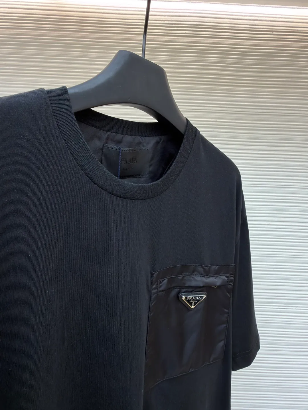 Prada Triangle Logo Pocket Short Sleeves ●Original version: Purchased and developed for 7000 ●Item number: 1682396-A05 ●Fabric: High-elastic jersey fabric ●Technology: Needle and shuttle stitching ●Color: black ●Version: Fitted version ●Weight: about 235 grams ●Size: S-M-L-XL ●Description: Customized high-elastic jersey material, delicate and soft, comfortable and close to the skin, a touch of simple white, pure and elegant. The iconic Prada triangle logo is embellished on the chest. It is integrated with Re-Nylon nylon fabric to decorate the square silhouette. Cross-disciplinary aesthetic grafting. The exquisite small pocket design highlights quality and style. It reveals a flexible and relaxed beauty. It is a picture of strolling in the city and deconstructs the attitude of the modern gentleman. The infrared positioning of the "Prada triangle mark" by an imported special machine is more precise and firm. Needle and shuttle stitching technology can make full use of the respective advantages of knitted fabrics and woven fabrics. By choosing the appropriate sewing process and stitches, it can ensure that the splicing parts are strong and beautiful. Template machine bag opening The preset template guides the position, shape and size of the bag opening. The accuracy ensures the quality of the bag opening effect. The overall wiring is straight and delicate, the fabric is comfortable and soft, and the color is consistent without color difference. It can be matched with the same style to create a fashionable look and control various occasions. Customized accessories, complete with three standards, same style for men and women!