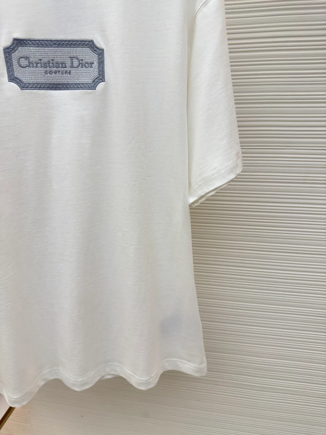 DIOR water-soluble embroidered logo short sleeves ●Authentic product: purchased and developed for 7400 ●Item number: 1680225-A00 ●Fabric: combed cotton compact yarn ●Technology: embroidery ●Version: fitted version ●Weight: about 300 grams ●Size: XS-S-M-L ●Description: The fabric is made of 21s double-yarn combed cotton compact yarn, weight 280g, matched with 32s double-yarn flat machine 1*1 to weave ribs, the front blade embroidery is embroidered with Tajima machine imported from Japan, and polyester-cotton mercerized embroidery thread is used for the bottom The layers are padded with cold water-soluble fabric, and the outer ring is surrounded by overlapping three-dimensional embroidery. The inner letters are embroidered with short needles, and the lines are embroidered with double-needle tatami offset embroidery. The ready-made garments are washed and dissolved with water-soluble fabric. The embroidered part feels soft to the touch, and the inner lining does not cut the flesh when worn.