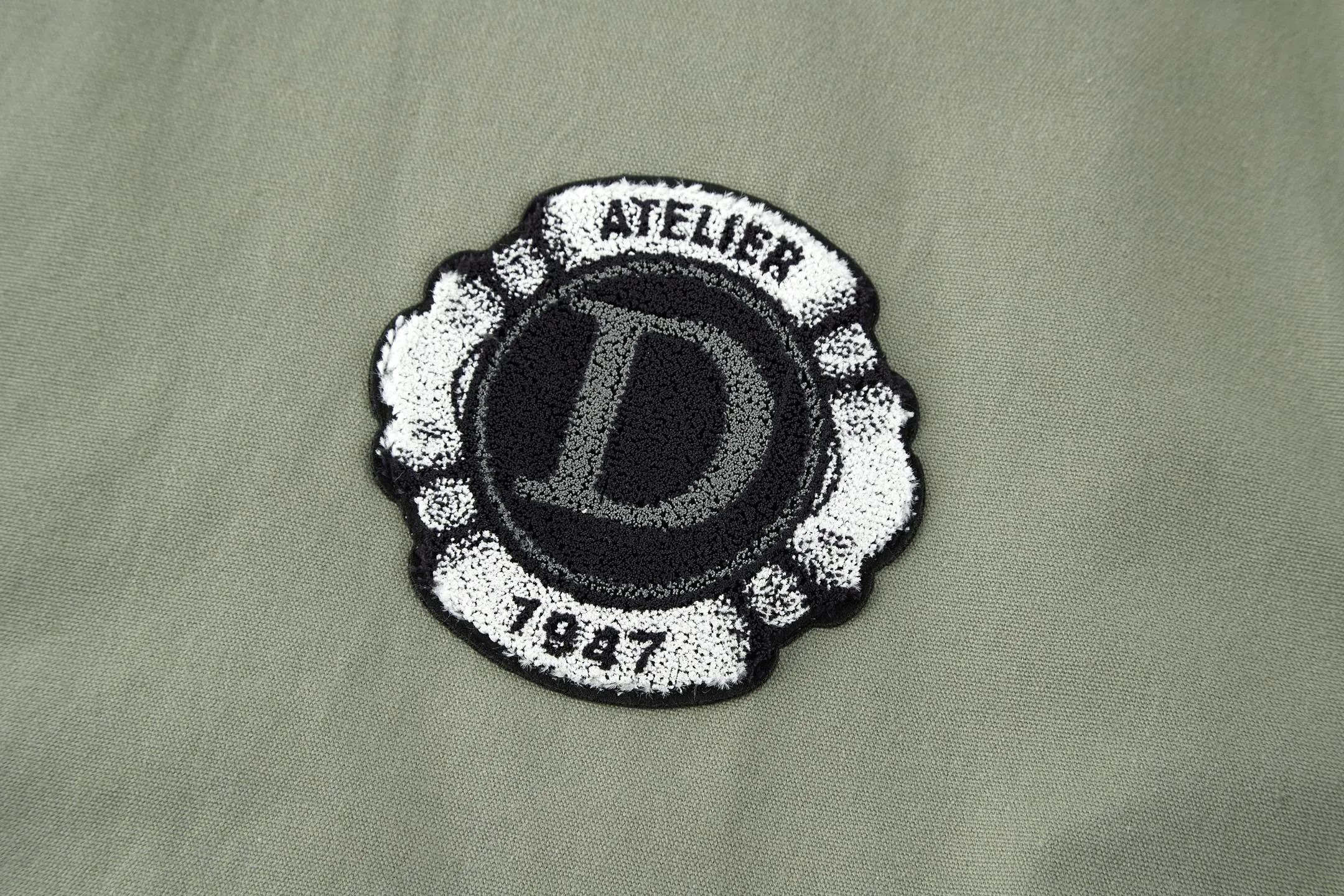 🅿️520 CD 1947 Badge Embroidered Baseball Jacket (Dark Green) The original version was purchased for 25,000 and developed. It is custom-woven cotton woven fabric with a slightly melting jacquard pattern. It is different from the texture of ordinary workwear on the market. The fabric feels very good. The main body of the back embroidery uses fixed-dye matte embroidery thread on the board and needle embroidery technology. Based on the overall size of the original image as the standard, the embroidery is accurately positioned with laser, and the edge is processed using a special overlocking method. The main lines of the pattern are outlined with needle embroidery and tatami embroidery can be used to fill in the background or details of the pattern. The pattern is embroidered with Tajima machine thousands of needles. The fine stitching method is dense and ultra-high density without revealing white. The pattern is clear and has a strong sense of lines and three-dimensionality. The added three-dimensional design enriches the spatial level of the overall picture. The hardware and accessories of the whole garment are all customized according to the original molding, with two-way zipper opening and closing, and a zipper puller engraved with the DR logo. Size:46-48-50-52