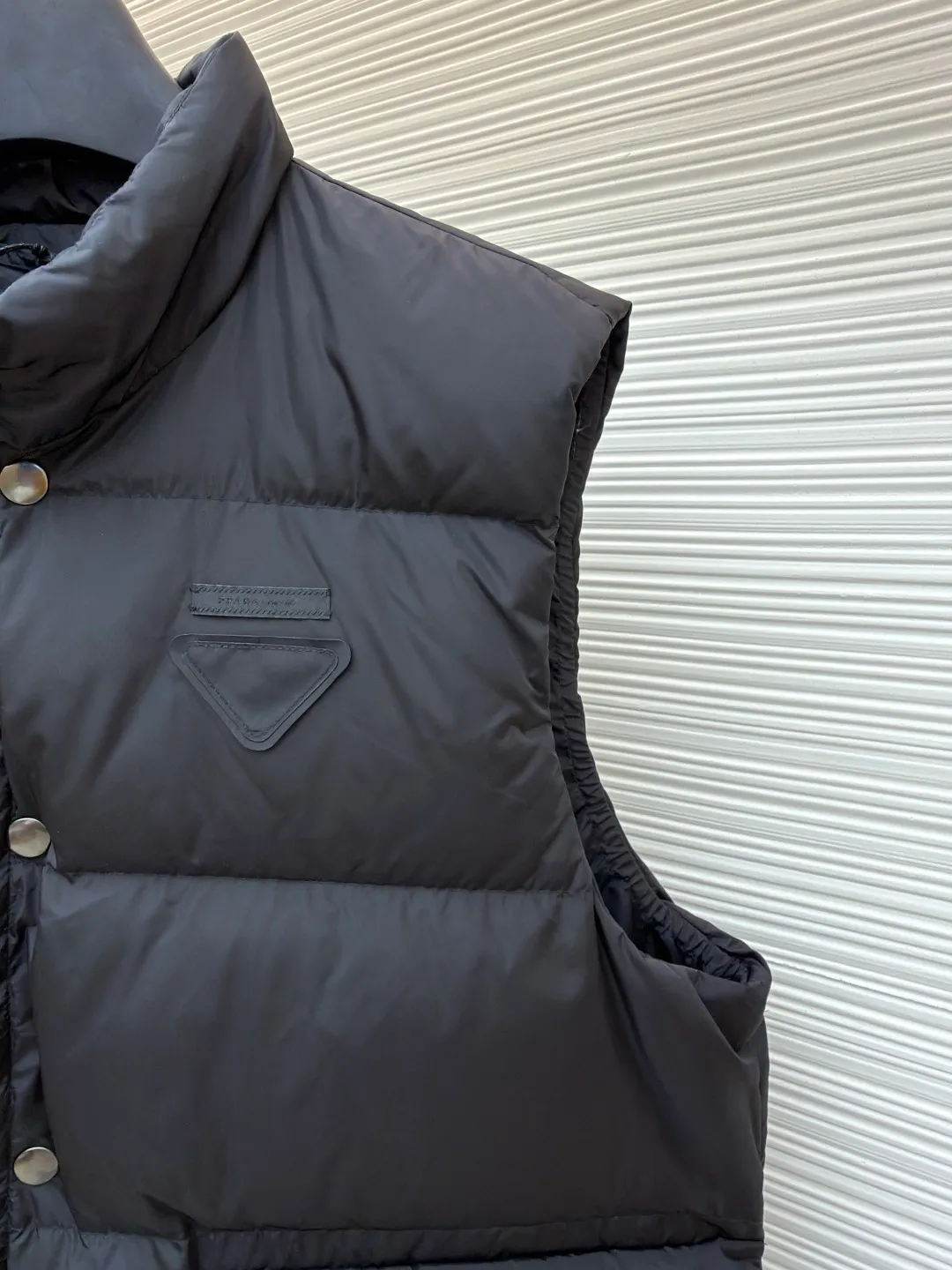 PRADA fabric triangle down vest ●Original version: purchased and developed by 12092 ●Item number: 1681119-C10 ●Fabric: white duck down fabric ●Technology: patch production ●Version: fitted version ●Weight: about 430 grams ●Size: 46-48-50-52 ●Description: The brand's iconic regenerated nylon fabric is selected, which has the same performance as traditional nylon, with high strength, tear resistance, wear resistance and other characteristics. It is lightweight and waterproof, suitable for various scenarios. Anti-wrinkle, quick-drying and easy to maintain on a daily basis. The felt cloth material is flatly fixed on the stamping machine table. Under the control of the ground controller, the upper mold is driven to move downward at extremely high speed and pressure. The sharp edge under pressure cuts off the felt cloth fibers instantly and cleanly like a paper knife. The whole process is completed within milliseconds. Through precise calculation, the triangle shape with no burrs and brushed edges is formed. It uses 90 white duck down with a weight of 160g to ensure excellent thermal insulation performance. After strict screening and processing, the velvet is not easy to drill, ensuring durability. The overall wiring is straight and delicate, the fabric is comfortable and soft, and the color is consistent without color difference. It can be matched with the same style to create a fashionable look and control various occasions. Customized accessories, complete with three standards, same style for men and women!
