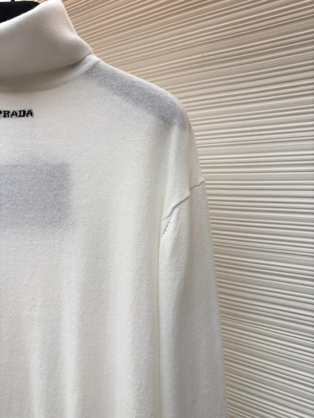 Prada jacquard turtleneck sweater ●Article number: 1681363-A75 ●Material: mercerized worsted wool fabric ●Technology: jacquard production ●Color: white ●Version: fitted version ●Weight: about 220 grams ●Size: 46-48-50-52 ●Description: Custom-woven mercerized worsted wool, soft and delicate, comfortable and close to the skin, with pure and clean white as the main color, restrained and layered, elegant and self-conscious The black PRADA logo forms a low-key dialogue with the soft sheen of white wool. It is accurately anchored under the collarbone at the visual golden section. It interprets PRADA's brand philosophy of minimalism and luxury. With the high-neck version as the core, functional warmth is sublimated into aesthetic expression. Less is more. With an inclusive attitude, it becomes the invisible base of all your looks. Made of jacquard tissue imported from Germany. Precisely control the arrangement and interweaving of yarns. Carefully intertwined on the loom. Prada logo jacquard art pattern inlay The fabrics are more vivid and three-dimensional, and the garment washing water is softened and deodorized using professional washing equipment and specific detergents to deeply clean and deodorize the clothes to improve the feel and appearance of the clothes. The overall wiring is straight and delicate, the fabric is comfortable and soft, and the color is consistent without color difference. It can be matched with the same style to create a fashionable look, and can be used in various occasions. Customized accessories, complete with three standards, the same style for men and women.