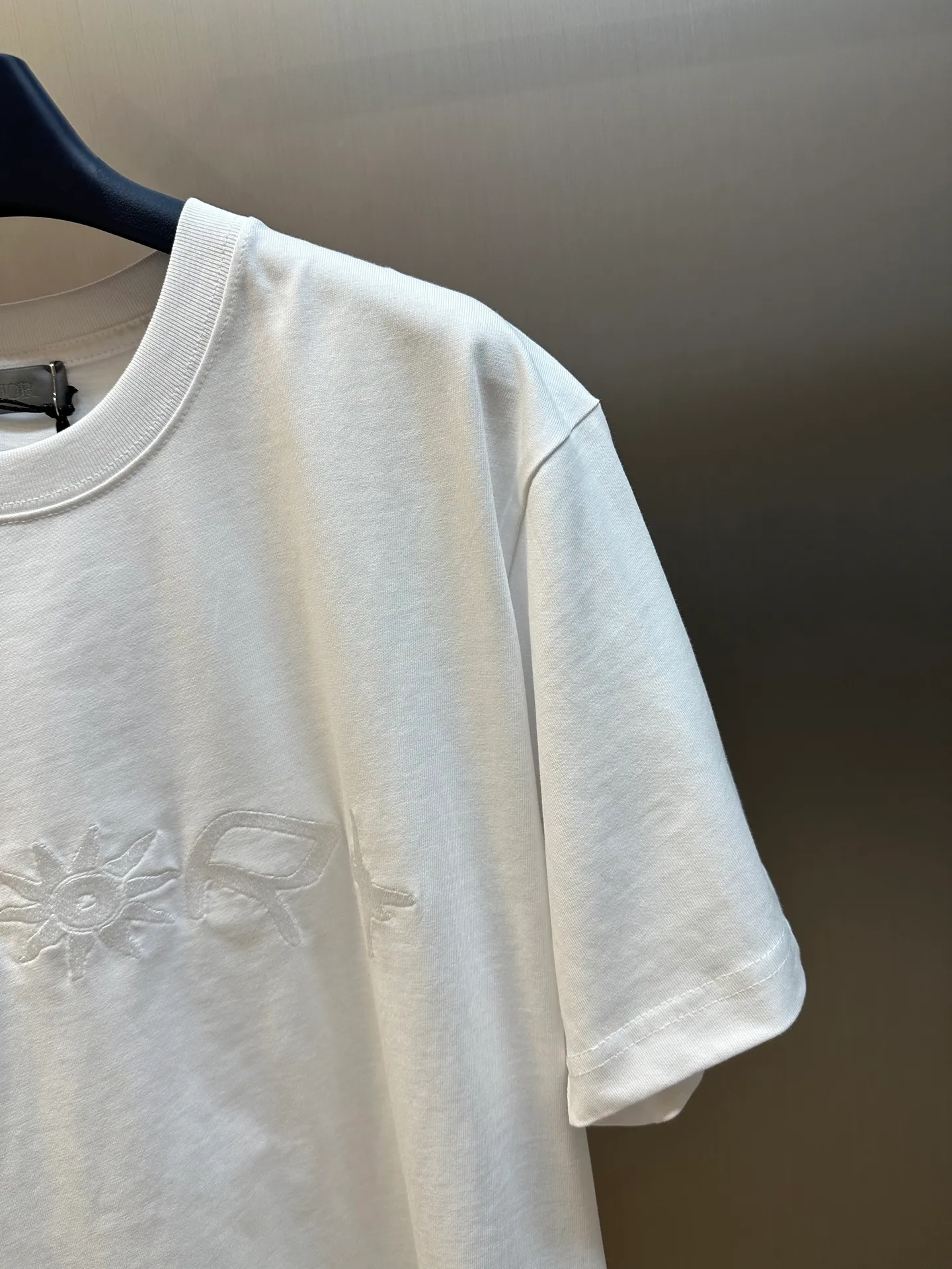 🅿️260 Dior co-branded embroidered round neck short-sleeved cotton jersey fabric, made of 15S fine cotton plain weave, 230g; paired with threaded 32S double yarn rack, 300g. 15S is a relatively thick yarn used to make thicker and more durable fabrics. The fabric made of pure cotton natural fiber has the characteristics of good hygroscopicity, strong breathability, softness and comfort. Cotton fabrics are generally suitable for summer wear and can help keep your body dry and comfortable. The yarn passes alternately in the horizontal and vertical directions to form a simple cross structure; it has good elasticity and wear resistance.  It is processed by needle embroidery process, and the main body adopts precision needle embroidery process; the embroidery is very fine and dense, the pattern is clear and the lines and three-dimensional sense are strong. The linen material embroidery thread is combined with encrypted processing, and the embroidery body has a subtle matte visual texture; the embroidery effect is three-dimensional and full. The flat embroidery has a unique needle-to-needle design, and the embroidery is very fine and dense. The overall stitching is fine, with consistent fineness and texture, adding a sense of layering to the simple design.  The standard round neck and short-sleeved version has a rounded arc neckline, which is suitable for various face shapes and body shapes; the sleeve length is moderate and ends just above the elbow, showing a smart and neat image. The slim fit can show off the wearer's body curves without sacrificing comfort. The collar, cuffs, hem and other parts are all sewn with fine double-needle stitching.  size：xs s m l