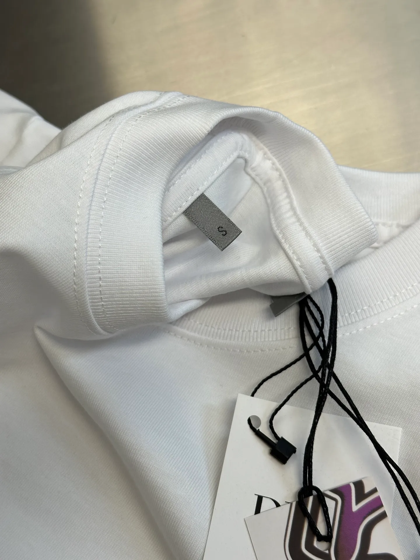 🅿️260 Dior co-branded embroidered round neck short-sleeved cotton jersey fabric, made of 15S fine cotton plain weave, 230g; paired with threaded 32S double yarn rack, 300g. 15S is a relatively thick yarn used to make thicker and more durable fabrics. The fabric made of pure cotton natural fiber has the characteristics of good hygroscopicity, strong breathability, softness and comfort. Cotton fabrics are generally suitable for summer wear and can help keep your body dry and comfortable. The yarn passes alternately in the horizontal and vertical directions to form a simple cross structure; it has good elasticity and wear resistance.  It is processed by needle embroidery process, and the main body adopts precision needle embroidery process; the embroidery is very fine and dense, the pattern is clear and the lines and three-dimensional sense are strong. The linen material embroidery thread is combined with encrypted processing, and the embroidery body has a subtle matte visual texture; the embroidery effect is three-dimensional and full. The flat embroidery has a unique needle-to-needle design, and the embroidery is very fine and dense. The overall stitching is fine, with consistent fineness and texture, adding a sense of layering to the simple design.  The standard round neck and short-sleeved version has a rounded arc neckline, which is suitable for various face shapes and body shapes; the sleeve length is moderate and ends just above the elbow, showing a smart and neat image. The slim fit can show off the wearer's body curves without sacrificing comfort. The collar, cuffs, hem and other parts are all sewn with fine double-needle stitching.  size：xs s m l