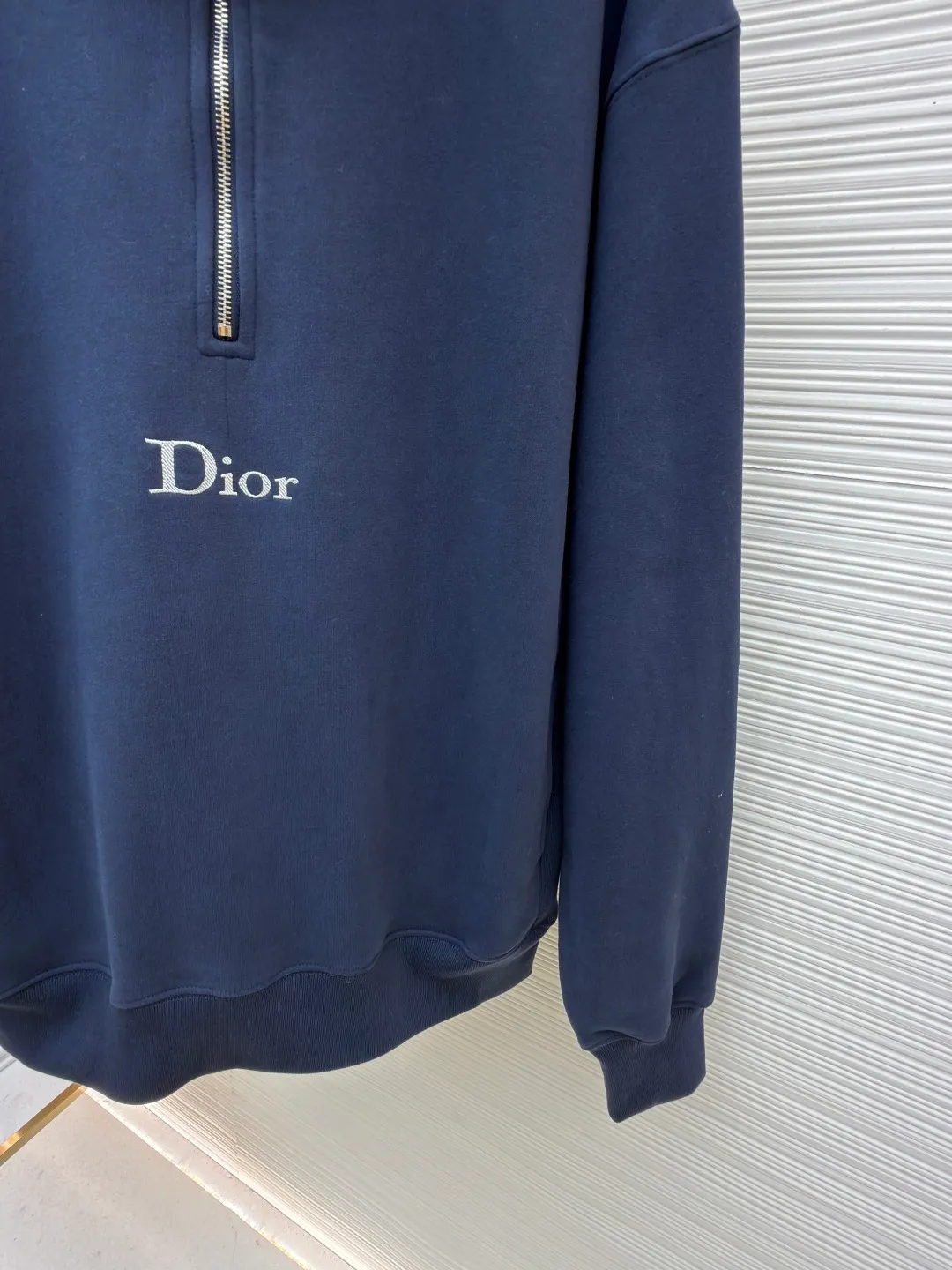 Dior half-zip logo sweatshirt ●Original version: 14,000 purchased and developed ●Item number: 1682497-A95 ●Material: pure cotton plush fabric ●Technology: twill logo embroidery production ●Color: blue ●Version: fitted version ●Weight: about 765 grams ●Size: XS-S-M-L ●Description: The fabric is a heavyweight high-end sweatshirt fabric. The 26-count double yarn forms the smooth and delicate outer surface of the fabric, while the 10-count plush yarn base is precision brushed to form a layer of rich, dense skin-friendly fluff, providing excellent softness and warmth. Its extremely high weight and elasticity brought by spandex ensure the ultimate thickness, stiffness and strong elastic recovery of the collar, cuffs and hem, which is the key to creating a neat silhouette and ensuring durability. Made of twill flat stitch embroidery. This is an embroidery technique that uses parallel stitches at specific angles to fill in, creating a flat, smooth and full embroidery surface with fine diagonal texture. The brand logo is presented in a delicate, strong and textured way, and the precision of the embroidery creates a high-end contrast with the casual feel of the sweatshirt fabric. The overall wiring is straight and delicate, the fabric is comfortable and soft, and the color is consistent without color difference. It can be matched with the same style to create a fashionable look and control various occasions. Customized accessories, complete with three standards, same style for men and women!