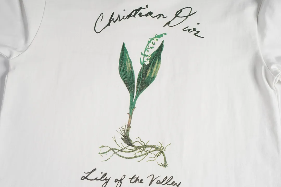 🅿️180 CD New lily of the valley loose-fitting short-sleeved fabric: 24S special woven compact cotton fabric 260g Rib: 40S double yarn rib; 280g This T-shirt is decorated with a delicate lily of the valley flower print, paying tribute to the beauty of the plant. Crafted from white cotton-jersey, it features a handwritten Christian Dior signature print on the chest. Easily create a casual look.  It is woven with 24-count special compact cotton yarn. The weaving process requires high standards and requires the use of advanced looms and high-quality raw materials. Specially woven compact cotton has many advantages, such as softness and comfort, good breathability, strong wrinkle resistance, good durability, etc.; it has a tighter, softer and more delicate texture and feel.  In the nylon solid slurry penetration printing process, you first need to apply nylon solid slurry on the pattern, and then make the slurry penetrate into the fabric through hot pressing or drying. During the penetration process, the slurry will chemically react with the fabric fibers to form a strong adhesion layer, making the pattern more vivid and full. Size: XS S M L