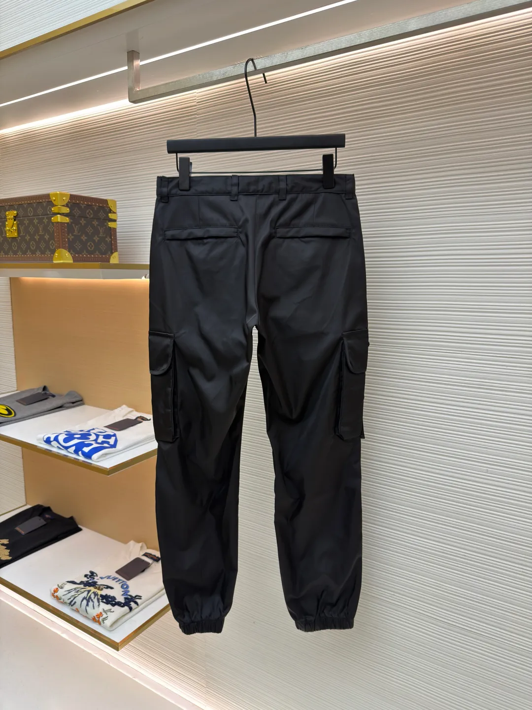 Prada iron brand triangle casual trousers ●Original version: purchased and developed by 6809 ●Item number: 1682077-B50 ●Fabric: nylon fabric ●Technology: made on positioning cutting machine ●Color: black ●Version: fitted version ●Weight: about 415 grams ●Size: 30-31-32-33-34-36 ●Description: This Prada work trousers are made of the brand's iconic regenerated nylon fabric. It has undergone a special water-repellent treatment process to make the fabric both lightweight and wear-resistant, with a delicate matte satin texture on the surface. The body of the trousers adopts three-dimensional tailoring technology and is combined with a multi-piece splicing structure to create an ergonomic trousers silhouette; the cargo pockets on both sides are reinforced with double-layer sewing technology, and the pocket openings are decorated with metal buckles and webbing. They are manually assembled and adjusted to ensure smooth opening and closing. The waistband has a built-in drawstring design. The drawstring is heat-cut and edge-sealed to prevent loosening. The rib cuffs of the trousers are made of high-elastic spandex blend material and are shaped through a shaping process to ensure long-lasting elasticity. The triangular logo on the pocket is formed using a metal die-casting process and is polished and plated to reveal a delicate luster. Every stitching follows the brand's strict stitch length standards, demonstrating the essence of high-end clothing craftsmanship. The overall wiring is straight and delicate, the fabric is comfortable and soft, and the color is consistent without color difference. It can be matched with the same style to create a fashionable look and control various occasions. Customized accessories, complete with three standards, same style for men and women!