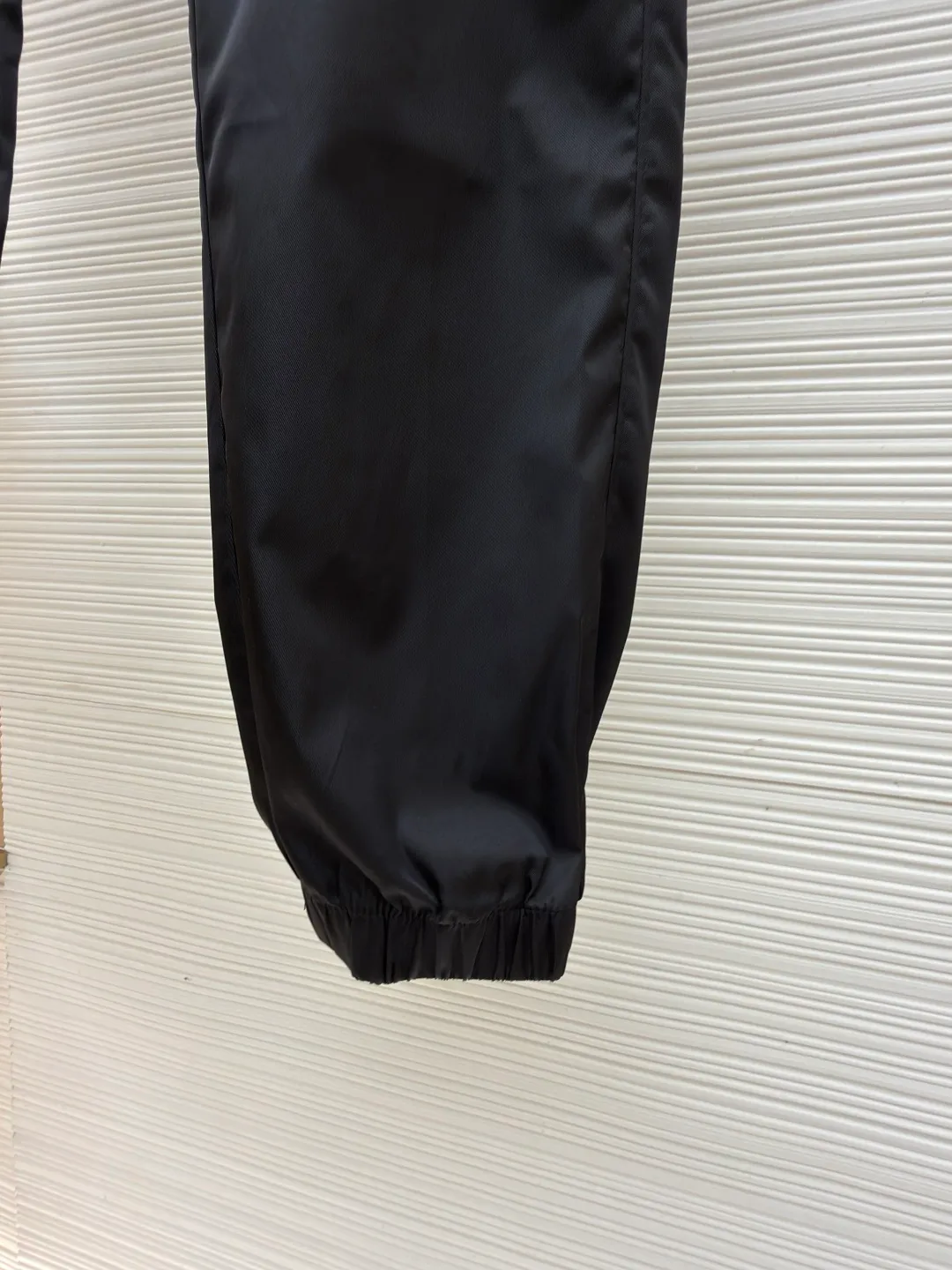 Prada iron brand triangle casual trousers ●Original version: purchased and developed by 6809 ●Item number: 1682077-B50 ●Fabric: nylon fabric ●Technology: made on positioning cutting machine ●Color: black ●Version: fitted version ●Weight: about 415 grams ●Size: 30-31-32-33-34-36 ●Description: This Prada work trousers are made of the brand's iconic regenerated nylon fabric. It has undergone a special water-repellent treatment process to make the fabric both lightweight and wear-resistant, with a delicate matte satin texture on the surface. The body of the trousers adopts three-dimensional tailoring technology and is combined with a multi-piece splicing structure to create an ergonomic trousers silhouette; the cargo pockets on both sides are reinforced with double-layer sewing technology, and the pocket openings are decorated with metal buckles and webbing. They are manually assembled and adjusted to ensure smooth opening and closing. The waistband has a built-in drawstring design. The drawstring is heat-cut and edge-sealed to prevent loosening. The rib cuffs of the trousers are made of high-elastic spandex blend material and are shaped through a shaping process to ensure long-lasting elasticity. The triangular logo on the pocket is formed using a metal die-casting process and is polished and plated to reveal a delicate luster. Every stitching follows the brand's strict stitch length standards, demonstrating the essence of high-end clothing craftsmanship. The overall wiring is straight and delicate, the fabric is comfortable and soft, and the color is consistent without color difference. It can be matched with the same style to create a fashionable look and control various occasions. Customized accessories, complete with three standards, same style for men and women!