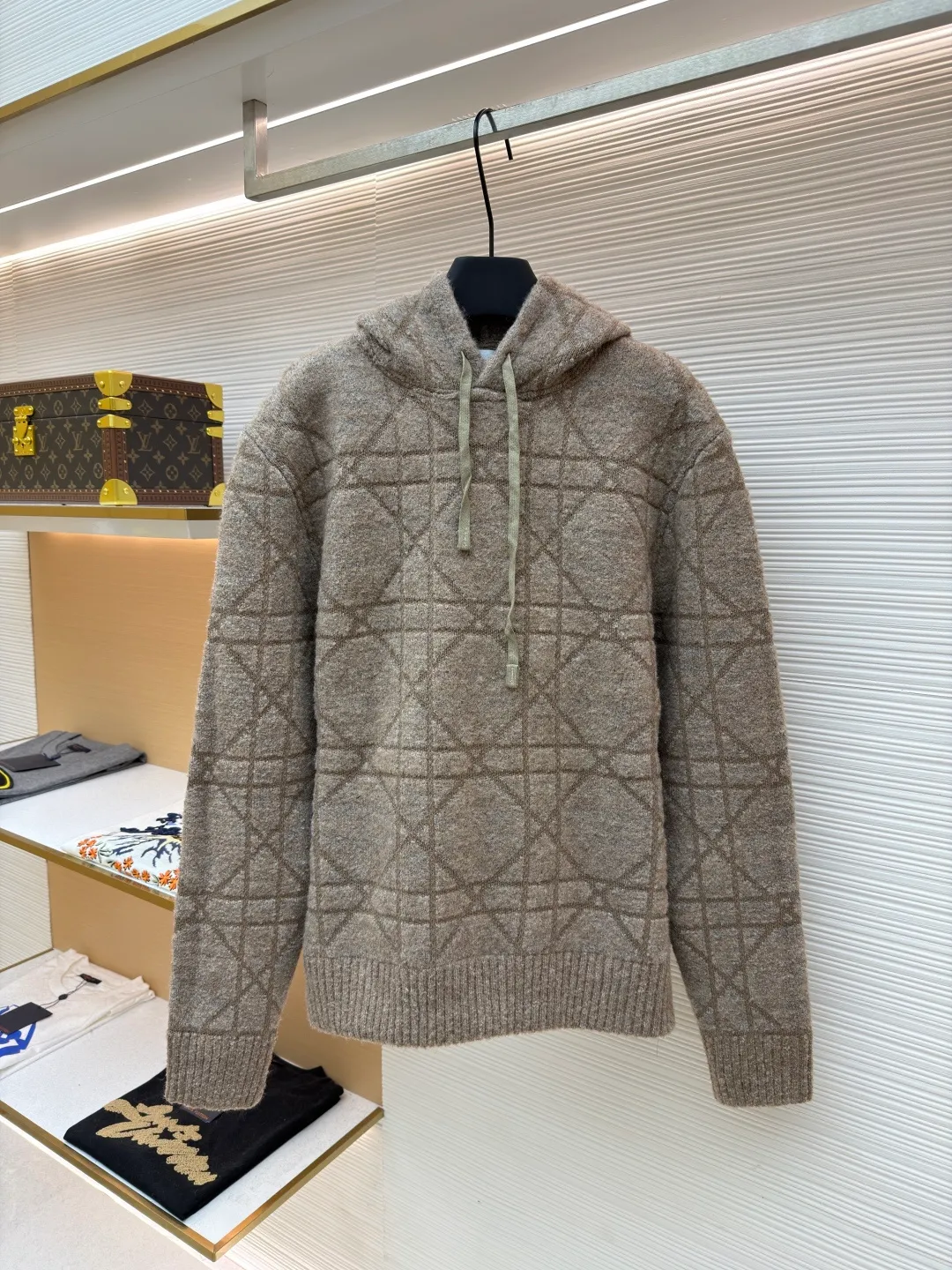 Dior diamond pattern jacquard knitted hoodie ●Original version: purchased and developed in 19726 ●Item number: 1681970-C70 ●Fabric: wool blended fabric ●Technology: jacquard knitting ●Color: camel ●Version: fitted version ●Weight: about 1315 grams ●Size: S-M-L-XL ●Description: This is LV The 2025 autumn and winter series of plush hooded sweaters are made of 100% Albaka wool blend, and the yarn contains 30% alpaca. It is woven with a 16-needle coarse weaving process. The surface presents a matte plush texture and is twice as warm as ordinary wool. The main body of the garment is made of rhombus plaid jacquard, with a three-dimensional texture formed by alternating front and back stitching techniques without additional seams. The hood is made of one-piece knitting, with an invisible shaping lining built into the brim, making it more comfortable to wear. The drawstring is made of core-spun rope of the same material, and the rope ends are treated with metal crimping, making it durable and not easy to wear. The finished product is ironed with low-temperature steam to avoid damage to the plush fibers. The cuffs and hem are ribbed for long-lasting elasticity and a good fit. The whole piece is sewn in an Italian workshop, with no exposed threads in the details, continuing the exquisite standards of the brand's high-end knitted items. The overall stitching is straight and delicate, the fabric is comfortable and soft, and the color is consistent with no color difference. It can be matched with the same style to create a fashionable look and control various occasions. Customized accessories, complete with three standards, the same style for men and women!