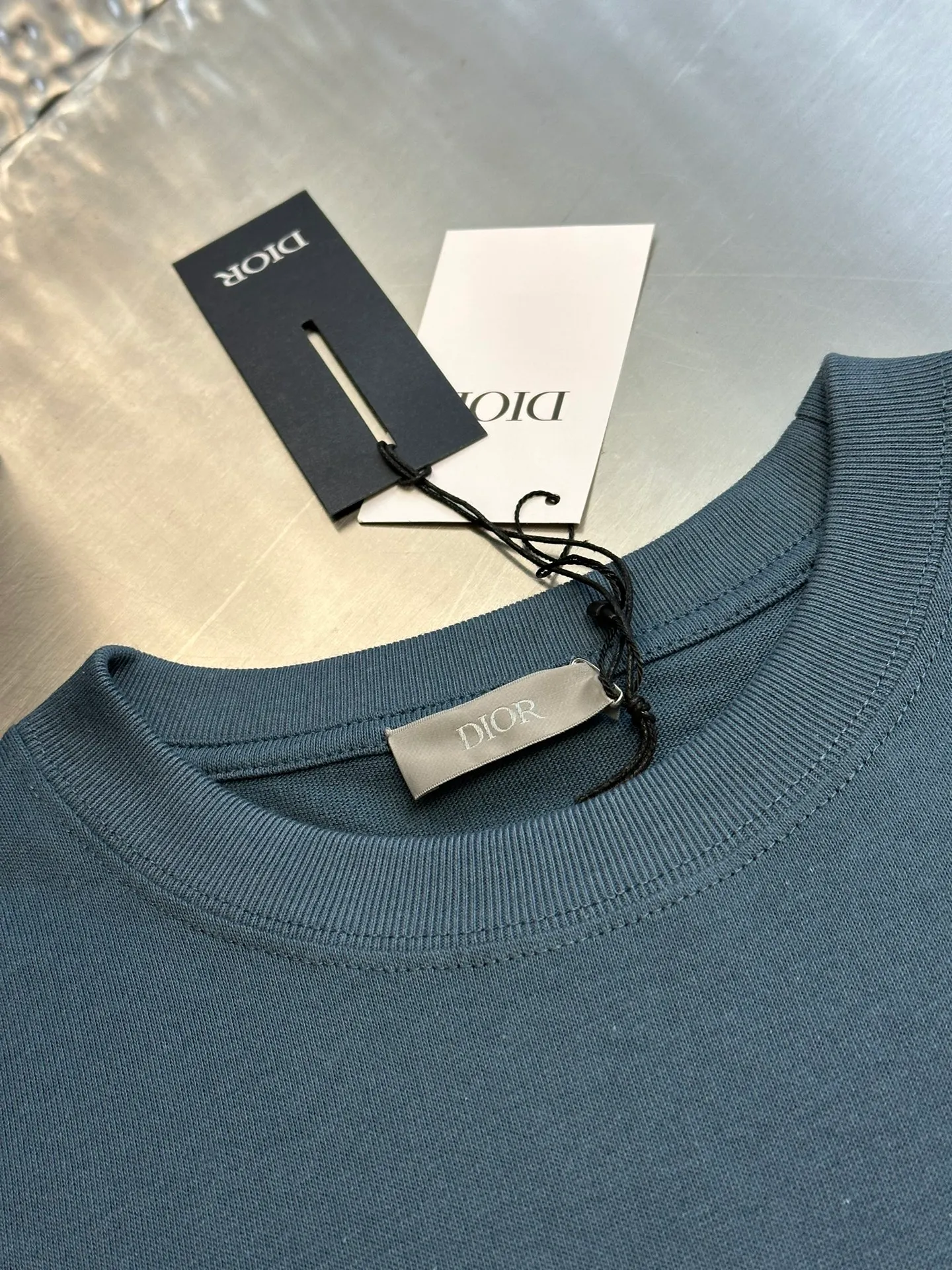 🅿️260 Dior patch letter short sleeves are made of pure cotton 12S fine cotton plain weave, weight 230g. The front is decorated with contrasting logo patches and small embroidered stamps, forming a decorative and iconic embroidery product. The logo is made of imported custom-made embroidery thread, which is dyed with lustrous mercerized embroidery thread, giving it a uniform and glossy finish. The exquisite embroidery machine combines complex embroidery needlework and fine detail processing to create a three-dimensional micro-relief embroidery effect; it is also highly durable and wear-resistant.  The standard round neck and short-sleeved version has a rounded arc neckline, which is suitable for various face shapes and body shapes; the sleeve length is moderate and ends just above the elbow, showing a smart and neat image. The slim fit can show off the wearer's body curves without sacrificing comfort. The collar, cuffs, hem and other parts are all sewn with fine double-needle stitching.  size：xs s m l