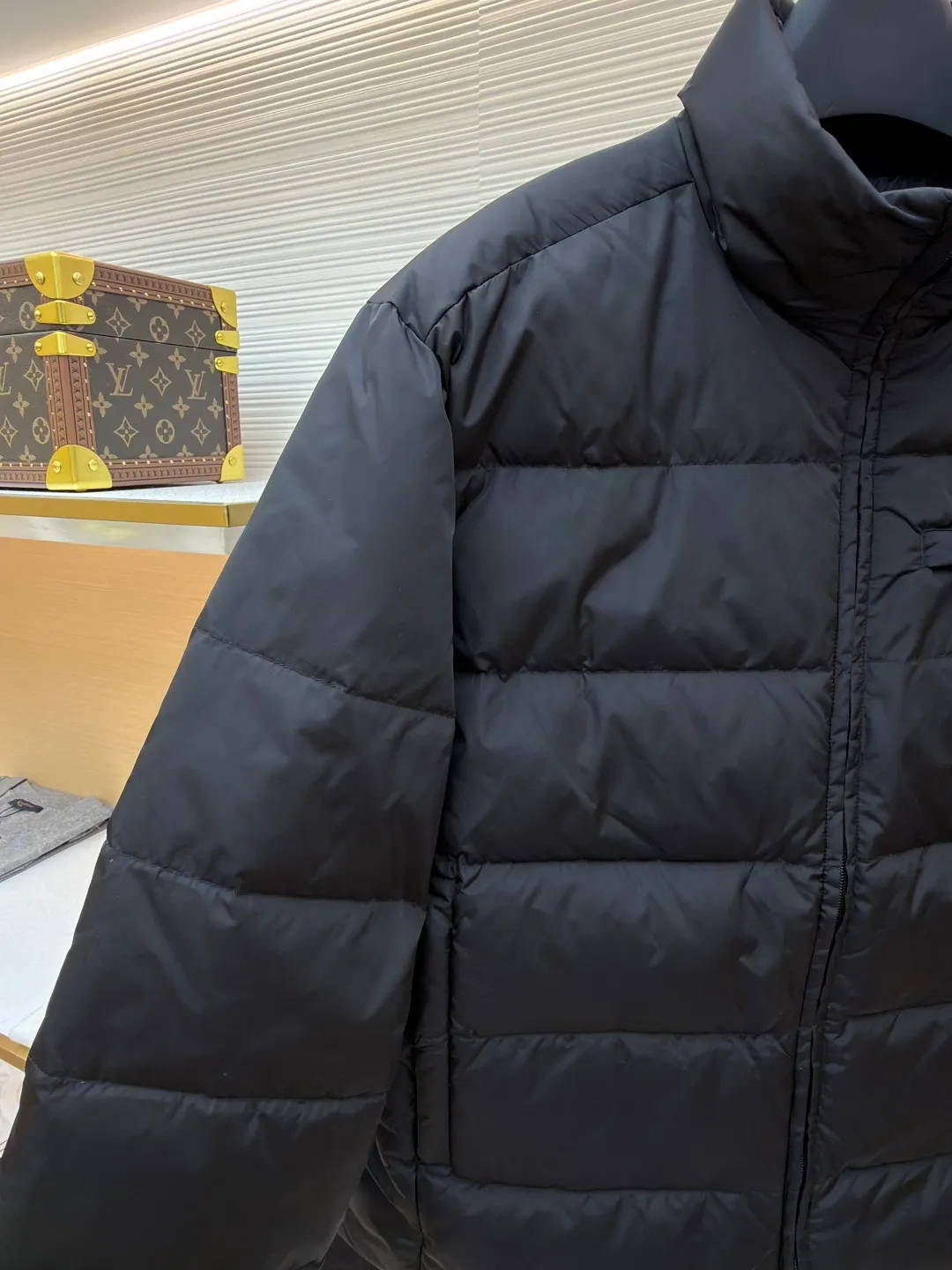 Prada triangle pocket down jacket ●Original version: Purchased and developed in 19800 ●Item number: 1681902-D20 ●Fabric: white duck down fabric ●Technology: mechanical down filling ●Color: black ●Version: fitted version ●Weight: about 675 grams ●Size: 46-48-50-52 ●Description: Customized ultra-dense round hole woven fabric (with anti-repellent treatment) showing a matte micro-texture Use the new national standard 90 white duck down (welcome to test), full of down, full of warmth, you are in a warm cloud, surrounded by soft warmth, the classic black tone exudes an innate sense of luxury, the iconic enameled metal triangle logo is embellished on the chest, low-key and powerful, the stand-up collar is crisp and stylish, accurately fits the neck curve, and uses architectural lines to reconstruct the warmth and neatness of the bloated down jacket. Enjoy warmth and comfort. Become the most considerate companion for mechanical down filling in winter. Prioritize the filling area by making the liner pattern to determine the gram weight of down per square meter according to the original three-dimensional effect, thereby calculating the filling amount of each piece. The computer down filling machine uses a digital weighing unit to achieve stable measurement, and uses imported special machine infrared to locate the "Prada triangle mark" for more accurate positioning. The firm and strong template machine opens the zipper bag. The lines are smooth and tidy. The wiring is even and the template machine lines the lines. The line process of the computer template machine shows extremely high neatness and smoothness. The craftsman accurately controls the size during the operation to ensure that each line meets the design requirements. The lines of the entire template are smooth and uniform, clean and beautiful. The overall wiring is straight and delicate, the fabric is comfortable and soft, and the color is consistent without color difference. It can be matched with the same style to create a fashionable look and control various occasions. Customized accessories, complete with three standards, same style for men and women!
