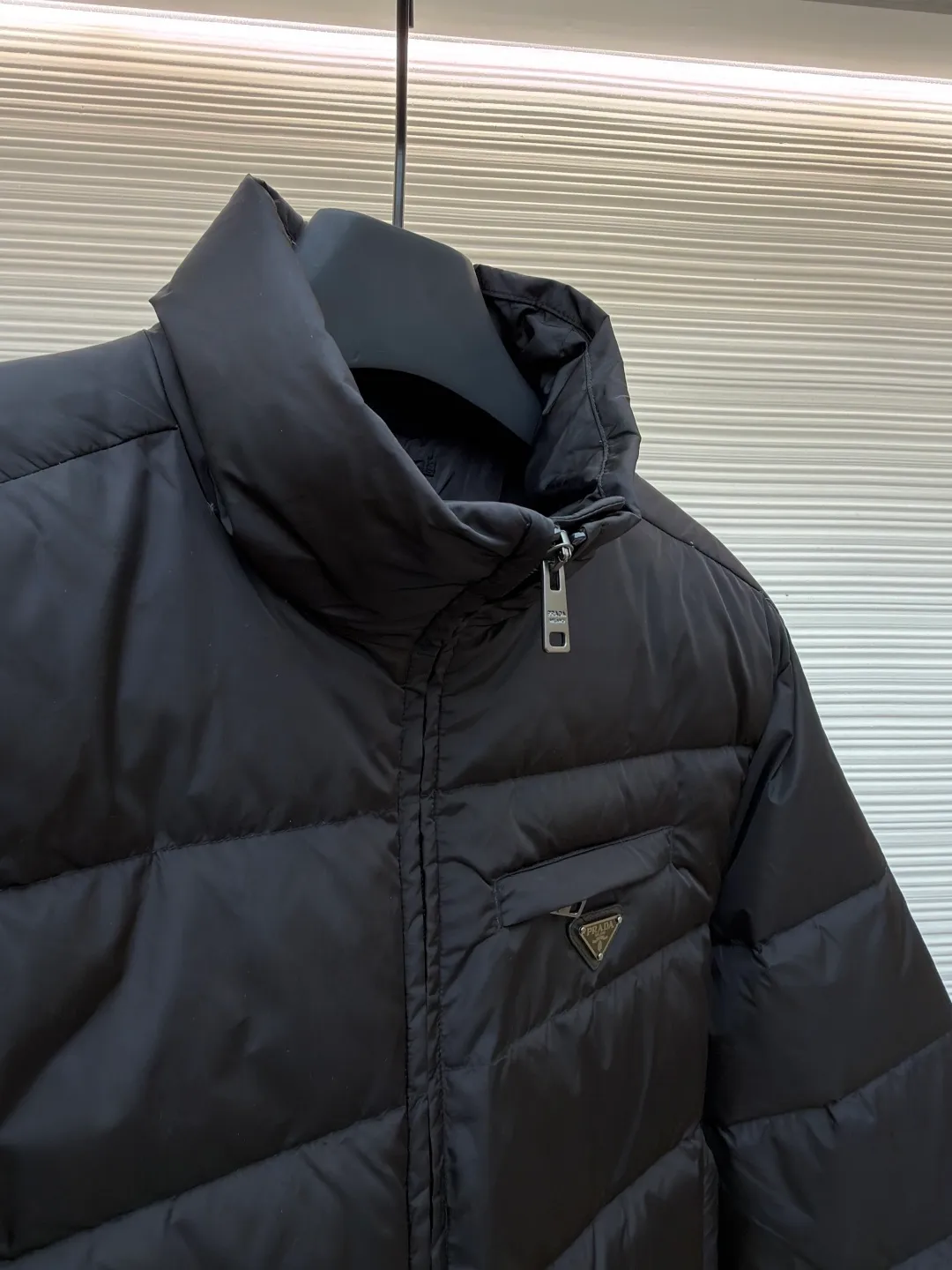Prada triangle pocket down jacket ●Original version: Purchased and developed in 19800 ●Item number: 1681902-D20 ●Fabric: white duck down fabric ●Technology: mechanical down filling ●Color: black ●Version: fitted version ●Weight: about 675 grams ●Size: 46-48-50-52 ●Description: Customized ultra-dense round hole woven fabric (with anti-repellent treatment) showing a matte micro-texture Use the new national standard 90 white duck down (welcome to test), full of down, full of warmth, you are in a warm cloud, surrounded by soft warmth, the classic black tone exudes an innate sense of luxury, the iconic enameled metal triangle logo is embellished on the chest, low-key and powerful, the stand-up collar is crisp and stylish, accurately fits the neck curve, and uses architectural lines to reconstruct the warmth and neatness of the bloated down jacket. Enjoy warmth and comfort. Become the most considerate companion for mechanical down filling in winter. Prioritize the filling area by making the liner pattern to determine the gram weight of down per square meter according to the original three-dimensional effect, thereby calculating the filling amount of each piece. The computer down filling machine uses a digital weighing unit to achieve stable measurement, and uses imported special machine infrared to locate the "Prada triangle mark" for more accurate positioning. The firm and strong template machine opens the zipper bag. The lines are smooth and tidy. The wiring is even and the template machine lines the lines. The line process of the computer template machine shows extremely high neatness and smoothness. The craftsman accurately controls the size during the operation to ensure that each line meets the design requirements. The lines of the entire template are smooth and uniform, clean and beautiful. The overall wiring is straight and delicate, the fabric is comfortable and soft, and the color is consistent without color difference. It can be matched with the same style to create a fashionable look and control various occasions. Customized accessories, complete with three standards, same style for men and women!