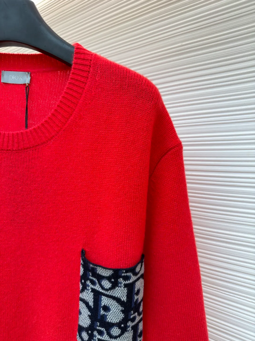 Dior patchwork letter jacquard pocket knitted sweater ●Original version: purchased and developed by 19049 ●Item number: 1682529-B10 ●Fabric: wool fabric ●Technology: jacquard knitting ●Color: red ●Version: fitted version ●Weight: about 475 grams ●Size: S-M-L-XL ●Description: This DIOR The SS26 summer series red sweater is woven with high-quality combed cotton threads and uses plain knitting technology to create the body. The fabric is fine, soft, elastic, breathable and skin-friendly, and is not prone to pilling or snagging. The brand's classic presbyopia pattern pocket on the left side of the body is made using patch printing technology. The printing ink layer is thick and even, and the pattern is clear and three-dimensional. It forms a sharp visual contrast with the red knitted base and highlights the brand recognition. The neckline is a classic round neck design, with double-needle reinforced hemming technology and a custom-made threaded collar, making it durable and not prone to loosening. The cuffs and hem are ribbed in the same color, with moderate elasticity to fit the body shape. The overall cut is a fitted silhouette. The stitching is straight and fine. The customized accessories and three labels are complete. The details and craftsmanship show the level of luxury. It is suitable for daily casual and light business wear scenarios. The overall wiring is straight and delicate, the fabric is comfortable and soft, and the color is consistent without color difference. It can be matched with the same style to create a fashionable look and control various occasions. Customized accessories, complete with three standards, same style for men and women!
