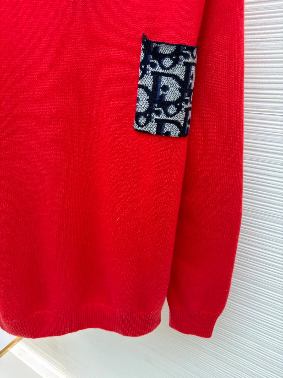 Dior patchwork letter jacquard pocket knitted sweater ●Original version: purchased and developed by 19049 ●Item number: 1682529-B10 ●Fabric: wool fabric ●Technology: jacquard knitting ●Color: red ●Version: fitted version ●Weight: about 475 grams ●Size: S-M-L-XL ●Description: This DIOR The SS26 summer series red sweater is woven with high-quality combed cotton threads and uses plain knitting technology to create the body. The fabric is fine, soft, elastic, breathable and skin-friendly, and is not prone to pilling or snagging. The brand's classic presbyopia pattern pocket on the left side of the body is made using patch printing technology. The printing ink layer is thick and even, and the pattern is clear and three-dimensional. It forms a sharp visual contrast with the red knitted base and highlights the brand recognition. The neckline is a classic round neck design, with double-needle reinforced hemming technology and a custom-made threaded collar, making it durable and not prone to loosening. The cuffs and hem are ribbed in the same color, with moderate elasticity to fit the body shape. The overall cut is a fitted silhouette. The stitching is straight and fine. The customized accessories and three labels are complete. The details and craftsmanship show the level of luxury. It is suitable for daily casual and light business wear scenarios. The overall wiring is straight and delicate, the fabric is comfortable and soft, and the color is consistent without color difference. It can be matched with the same style to create a fashionable look and control various occasions. Customized accessories, complete with three standards, same style for men and women!
