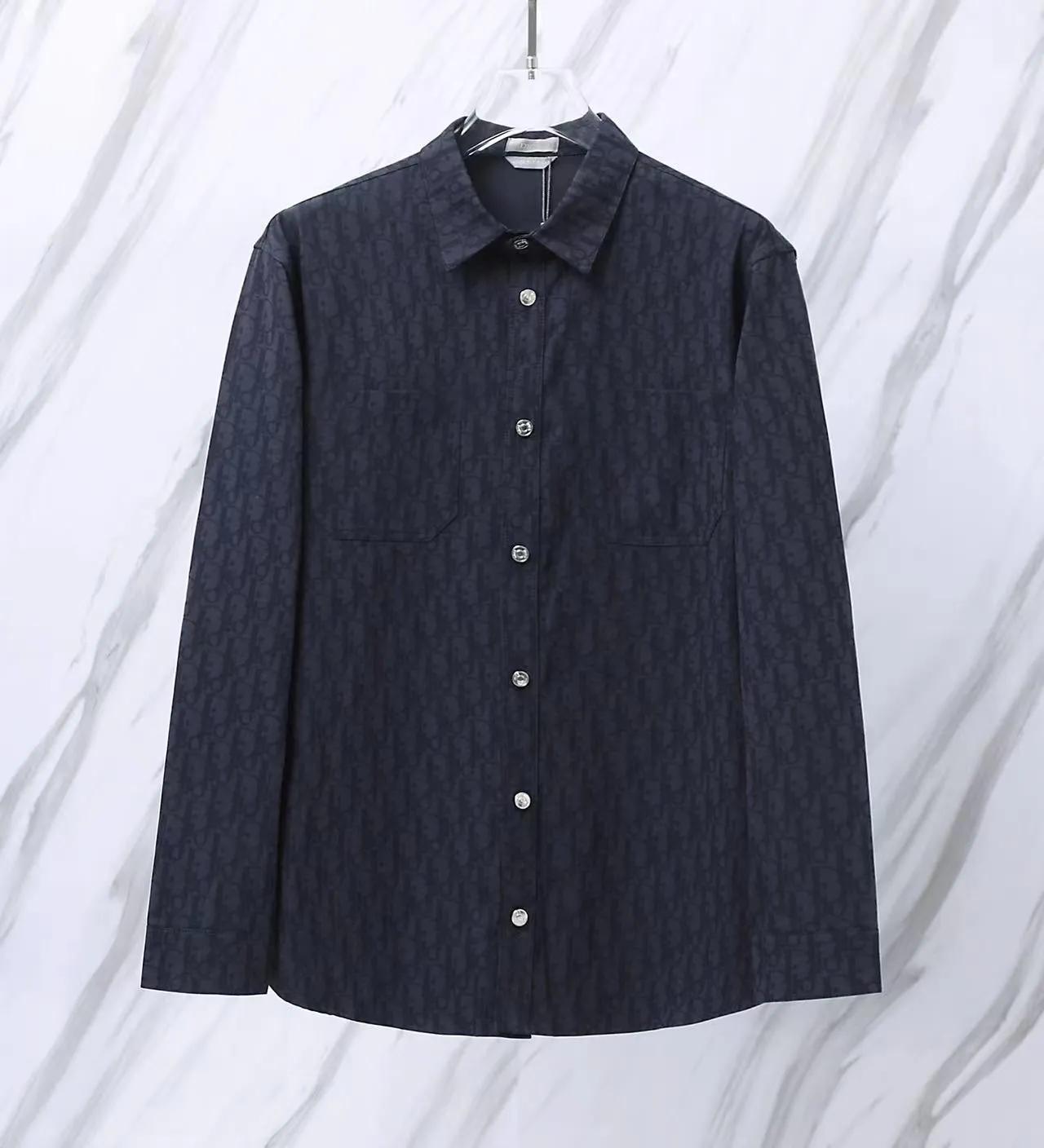 🅿️280 Item No.: D12 Dior/Dior DR letter-dyed all-over logo jacquard long-sleeved shirt. The fabric is made of high-quality custom-woven fabrics. It is independently completed in 36 processes in the own brand factory assembly line based on the original version. Exquisite workmanship, neat routing, fine stitch length, loose and versatile version, casual and fashionable. The buttons are made of exclusive molded and custom-made letter aluminum buttons, which are not easy to rust after being stored for a long time after washing. The "Dior" letters on the small buttons on the pockets are clearly visible. The letters on the fabric are printed using a discharge printing process, which is to change the color of the original yarn into dark blue. It is not the so-called printed or jacquard fabric on the market. The texture of the fabric is thick and stiff, and the fabric characteristics are not easy to wrinkle. The dyeing yarn restores the original color. The packaging uses a new packaging bag with DR letters. The packaging tags are complete. The same style for men and women. Color: dark blue Size: 38/39/40/41