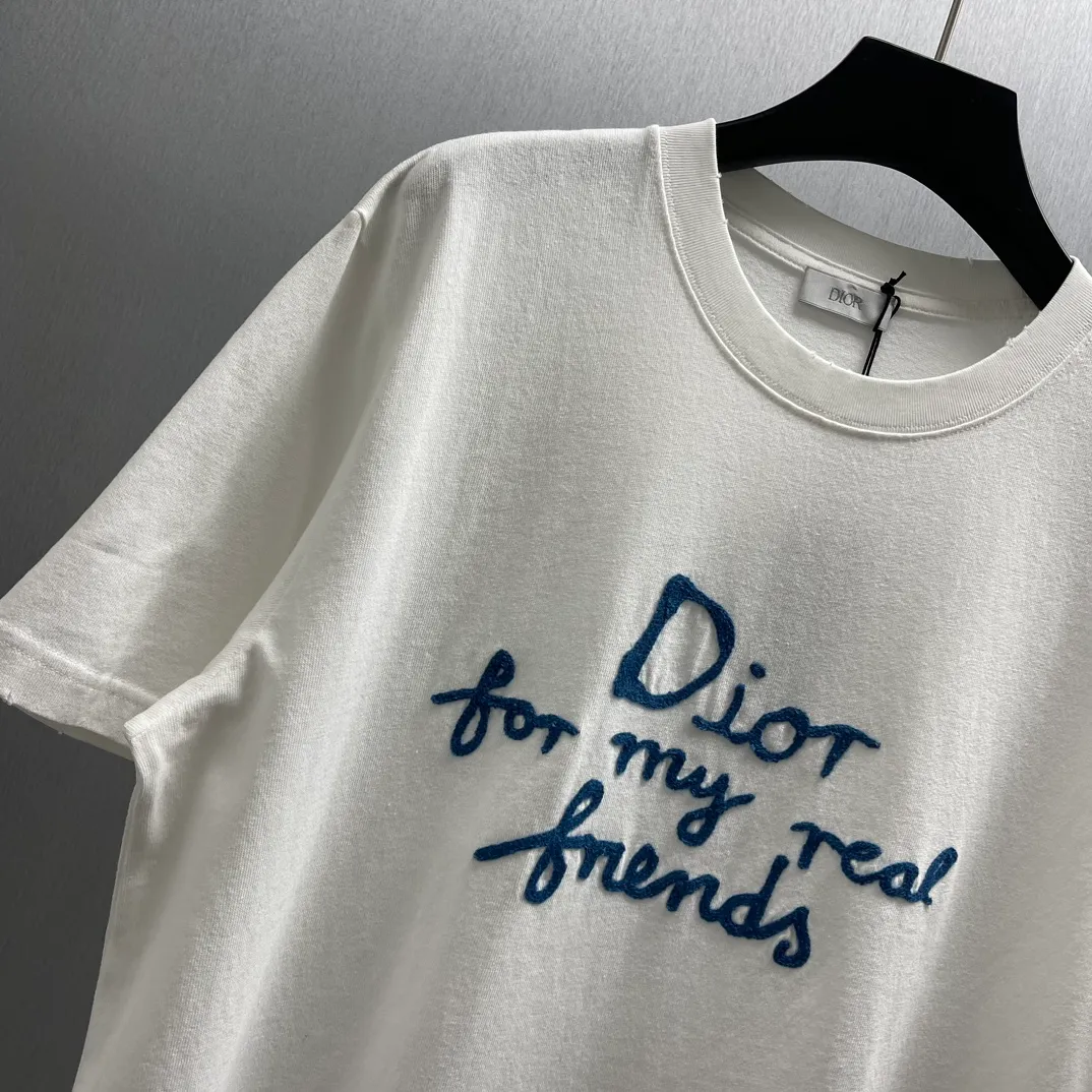 🅿️260 🧧CD True Friends Private Lettered Short Sleeves Size: S-XL This T-shirt displays the Dior For My Real Friends logo from the DIOR AND HYLTON NEL joint series. Crafted from white cotton jersey, it features a classic silhouette with a ribbed crew neck, embroidery on the chest for added style, and a burned-out effect on the collar, sleeves and hem. Cut for a relaxed fit, wear it with track pants or jeans.
