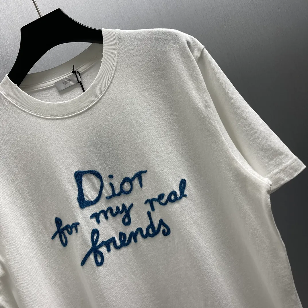 🅿️260 🧧CD True Friends Private Lettered Short Sleeves Size: S-XL This T-shirt displays the Dior For My Real Friends logo from the DIOR AND HYLTON NEL joint series. Crafted from white cotton jersey, it features a classic silhouette with a ribbed crew neck, embroidery on the chest for added style, and a burned-out effect on the collar, sleeves and hem. Cut for a relaxed fit, wear it with track pants or jeans.