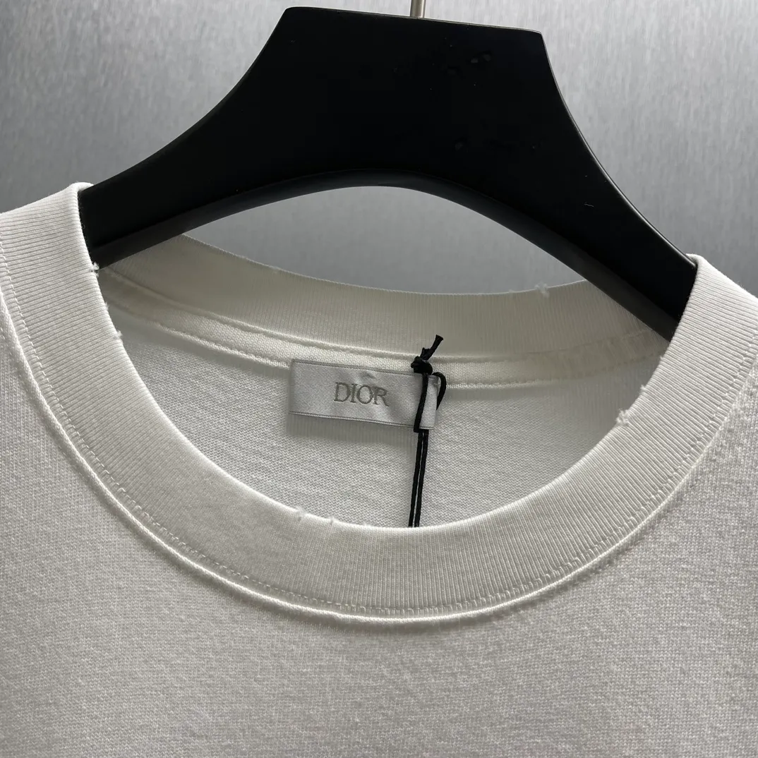🅿️260 🧧CD True Friends Private Lettered Short Sleeves Size: S-XL This T-shirt displays the Dior For My Real Friends logo from the DIOR AND HYLTON NEL joint series. Crafted from white cotton jersey, it features a classic silhouette with a ribbed crew neck, embroidery on the chest for added style, and a burned-out effect on the collar, sleeves and hem. Cut for a relaxed fit, wear it with track pants or jeans.