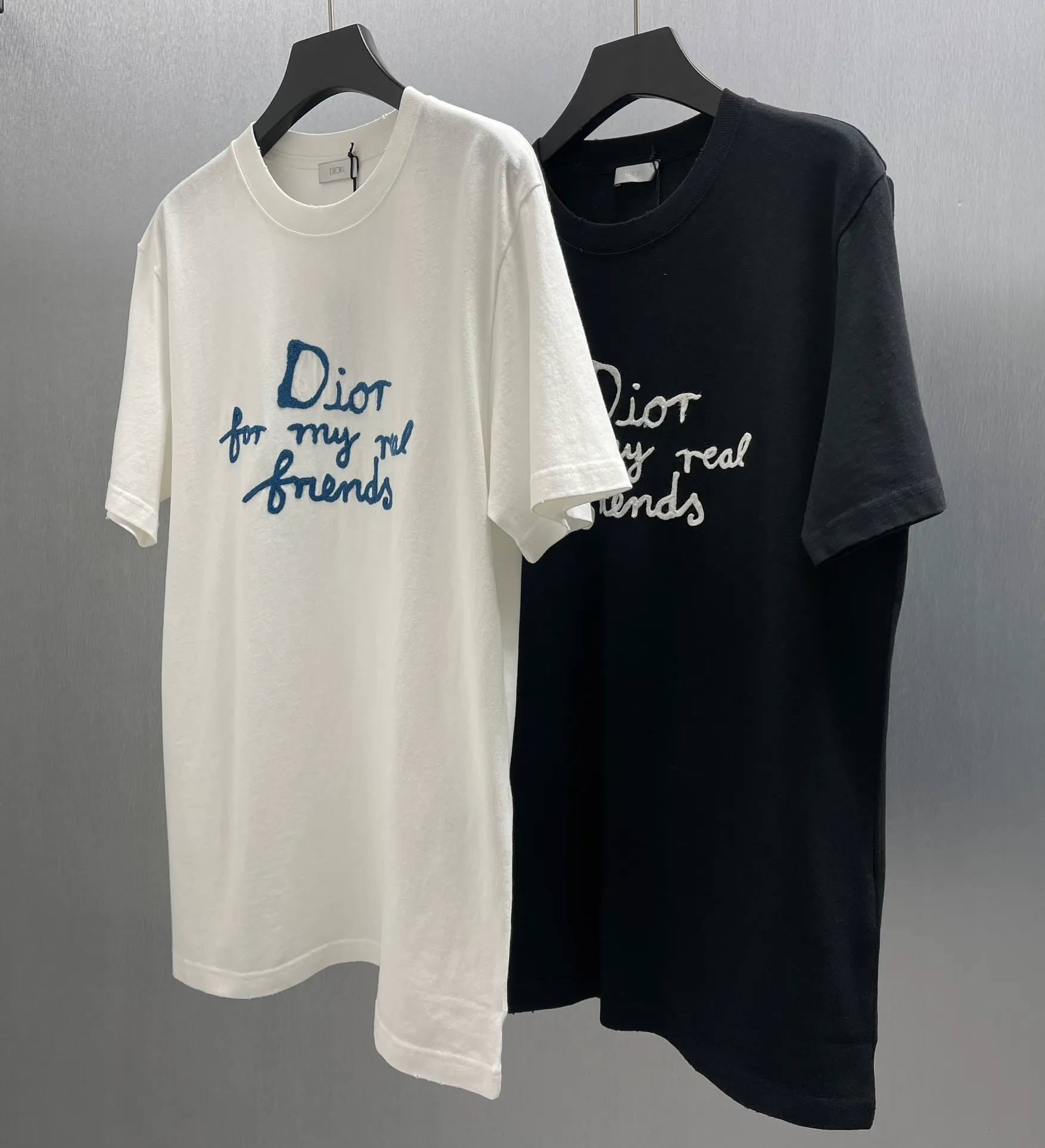 🅿️260 🧧CD True Friends Private Lettered Short Sleeves Size: S-XL This T-shirt displays the Dior For My Real Friends logo from the DIOR AND HYLTON NEL joint series. Crafted from white cotton jersey, it features a classic silhouette with a ribbed crew neck, embroidery on the chest for added style, and a burned-out effect on the collar, sleeves and hem. Cut for a relaxed fit, wear it with track pants or jeans.